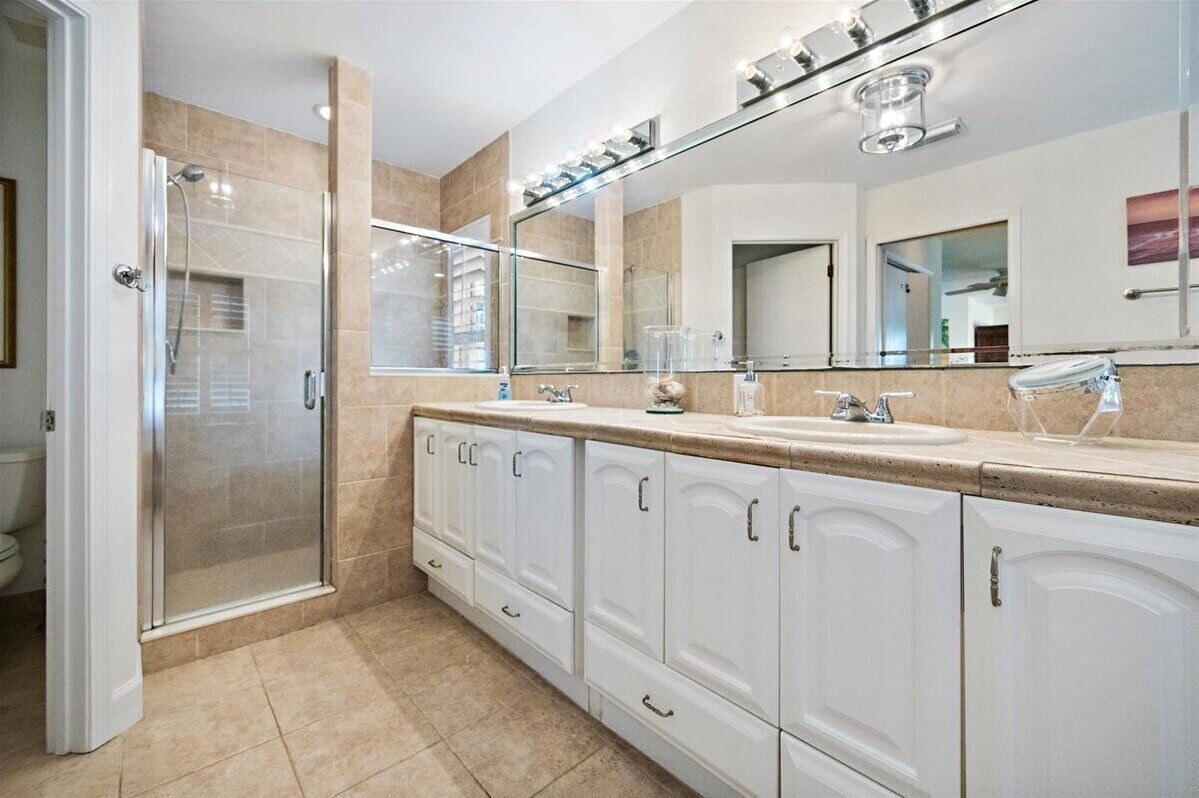 Primary suite bath with shower and separate large soaking tub. Two vanities.