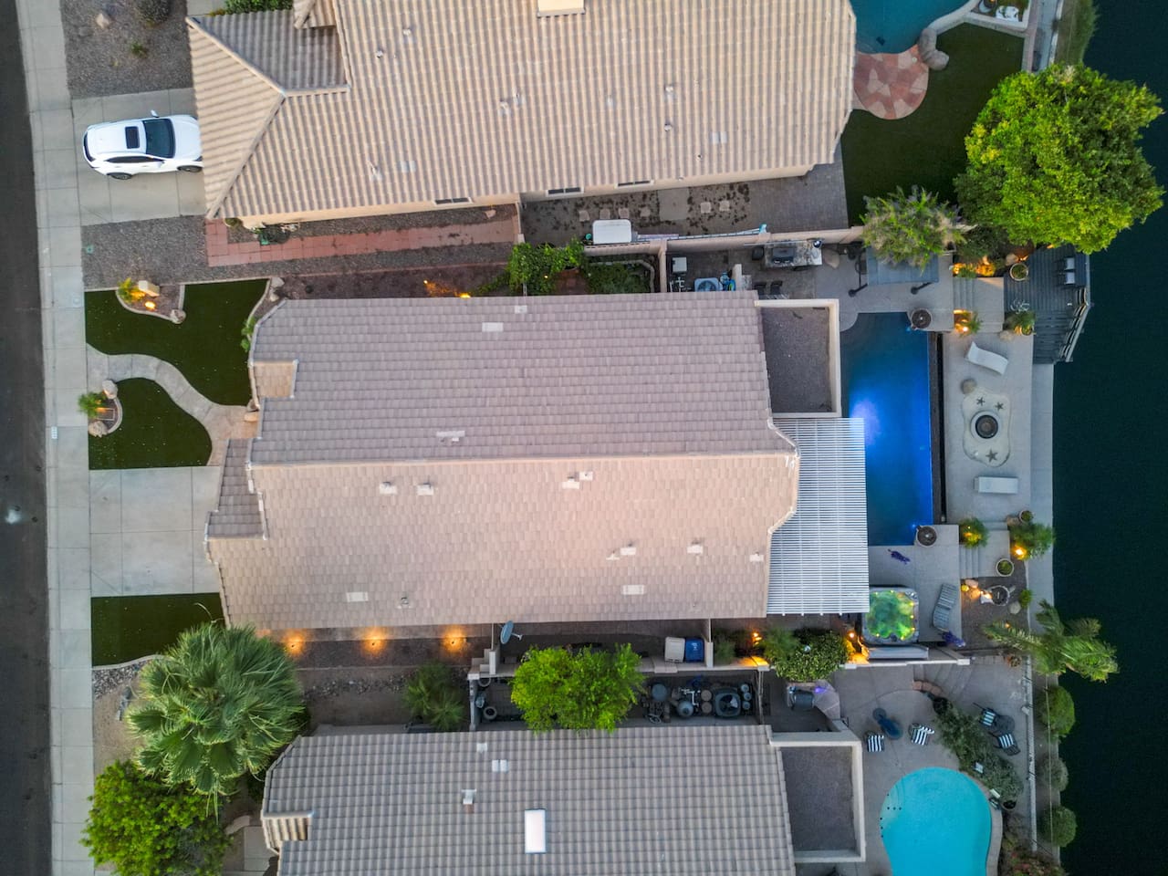 Directly overhead, the layout tells the story — a long private pool, lush landscaping, and lakeside access all contained within your own backyard retreat.