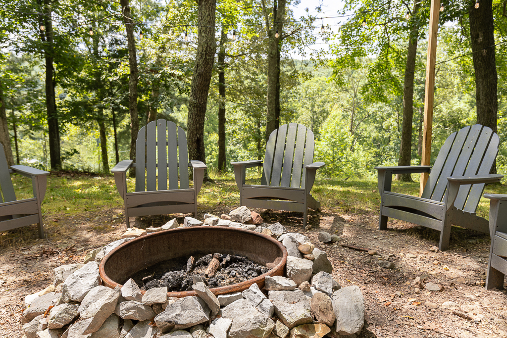 Rustic stone firepit surrounded by Adirondack chairs — the perfect place to gather and stay warm as the sun sets.