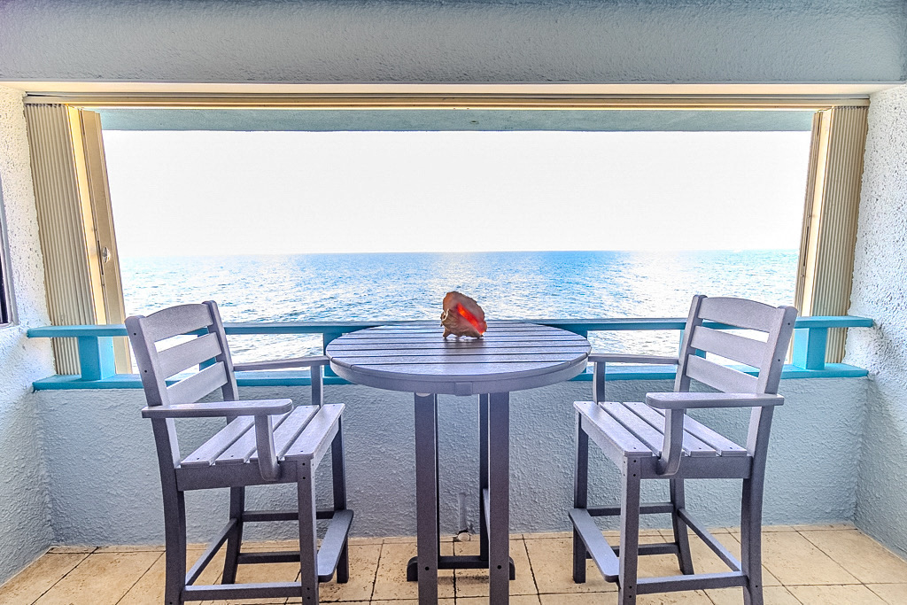 Dining set on the balcony&mdash;outdoor meals with ocean soundtrack.