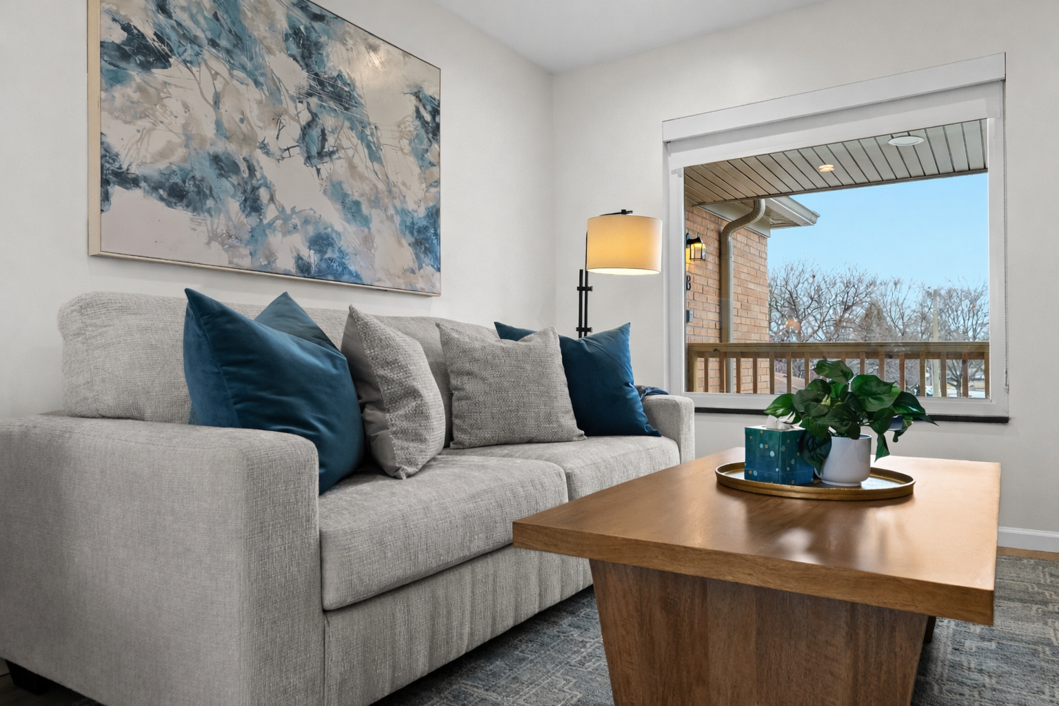 Relax in this bright living space with plush seating, modern decor, and natural light—perfect for unwinding or enjoying a cozy night in.