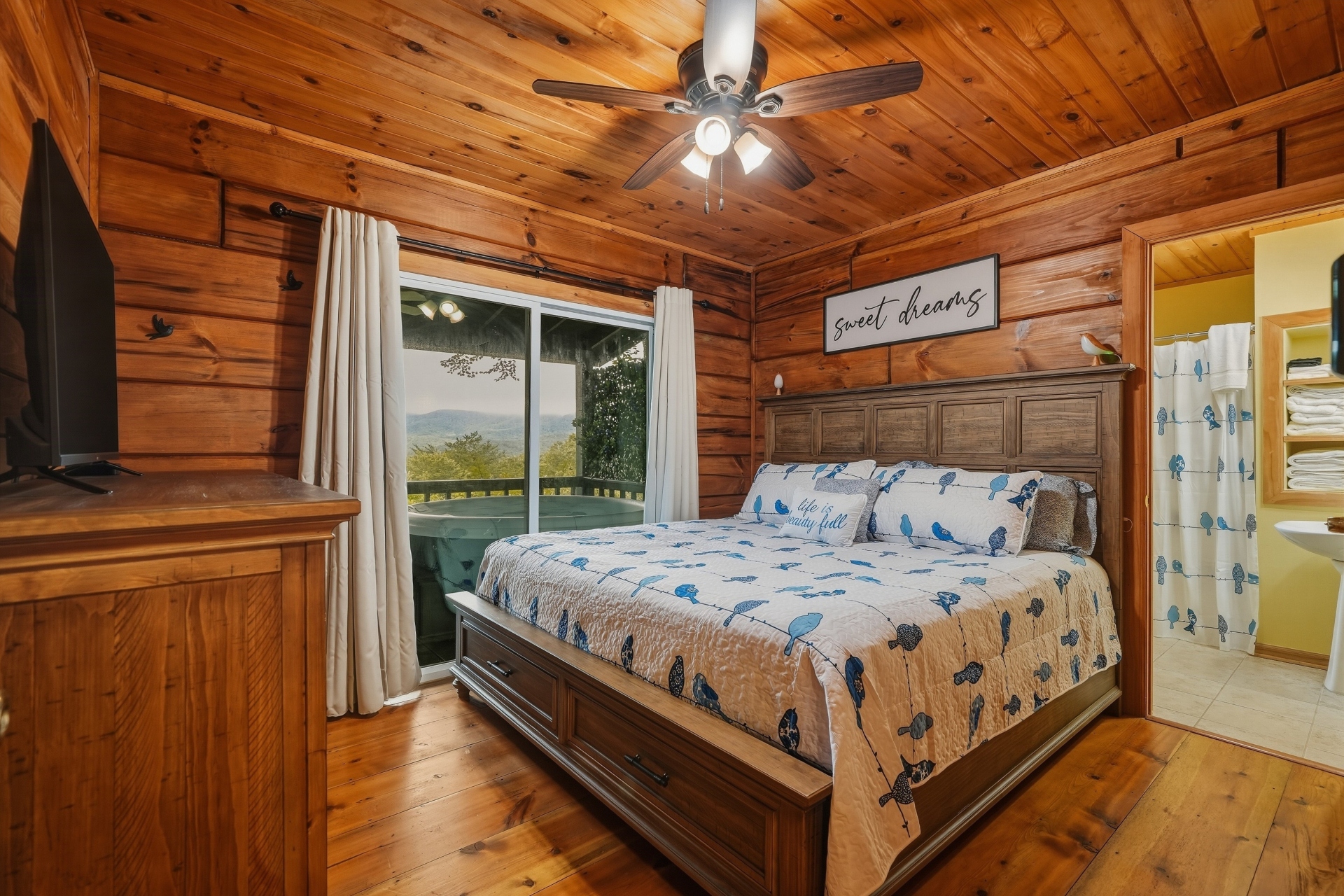 King bed with ceiling fan and smart TV