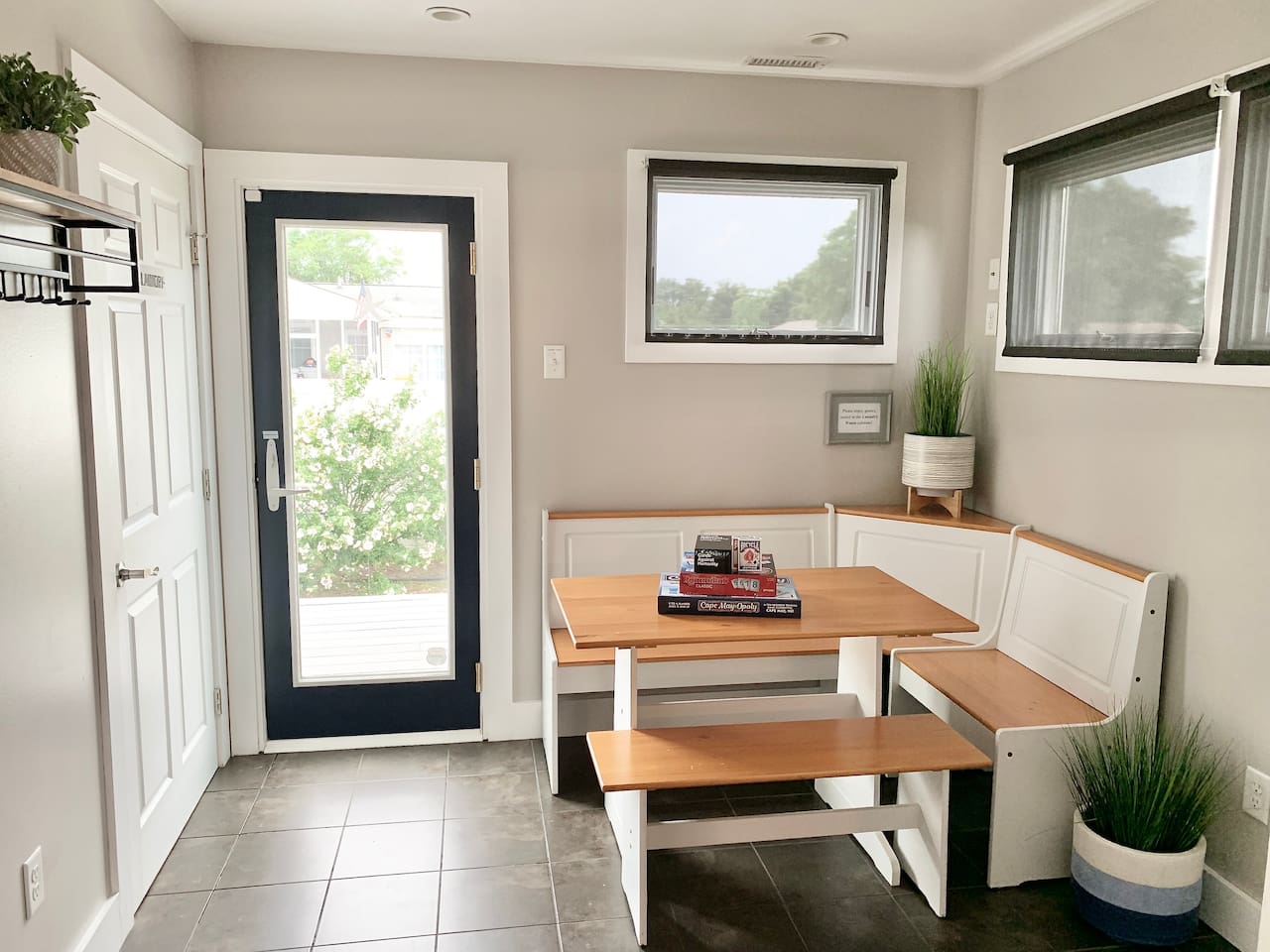 This sun-drenched breakfast nook features white corner bench seating and a light wood table. It’s the perfect spot to enjoy your morning coffee or play a board game while looking out at the yard.