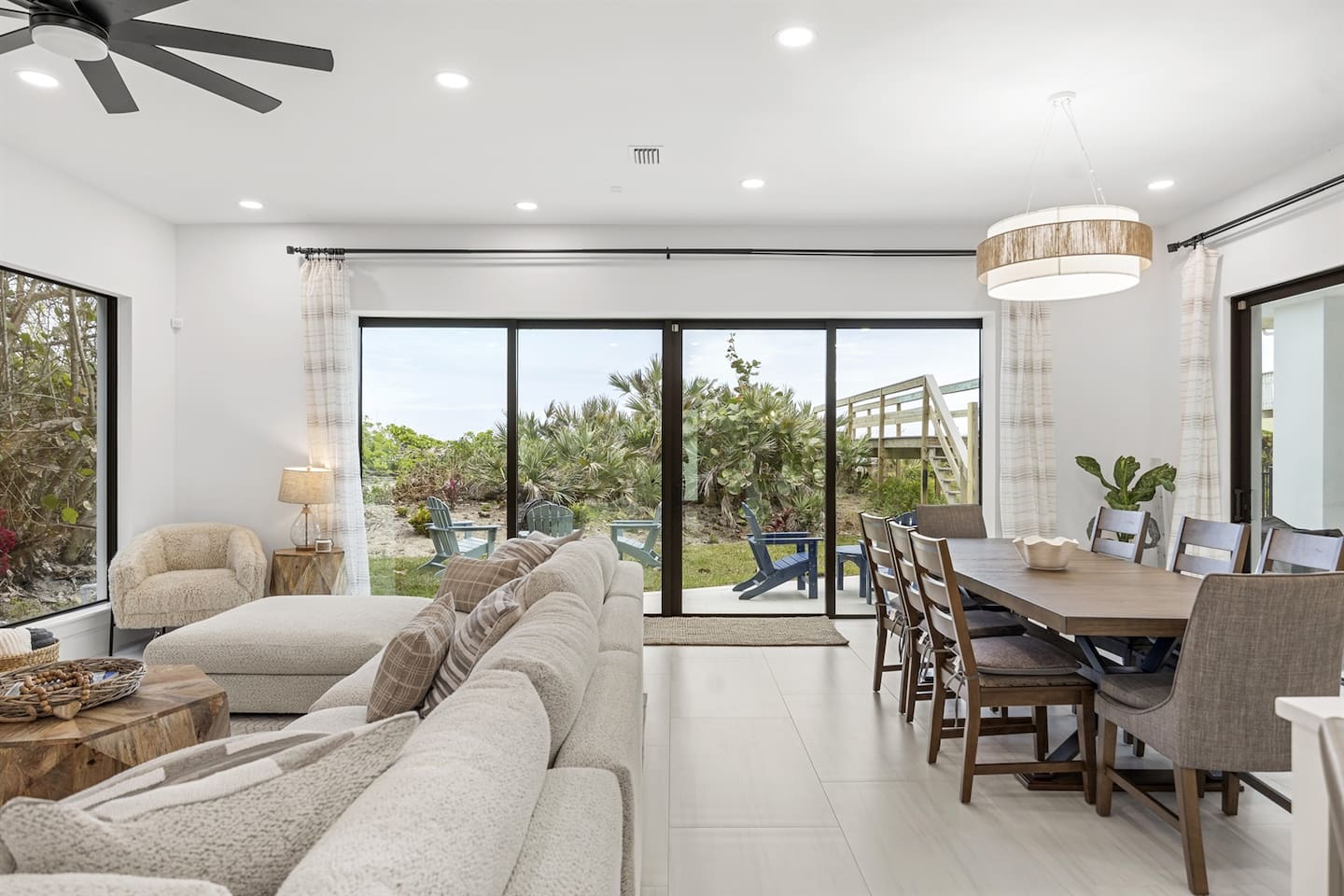 Open dining and living room with large glass windows and doors that seamlessly open to the backyard patio, perfect for indoor-outdoor living.