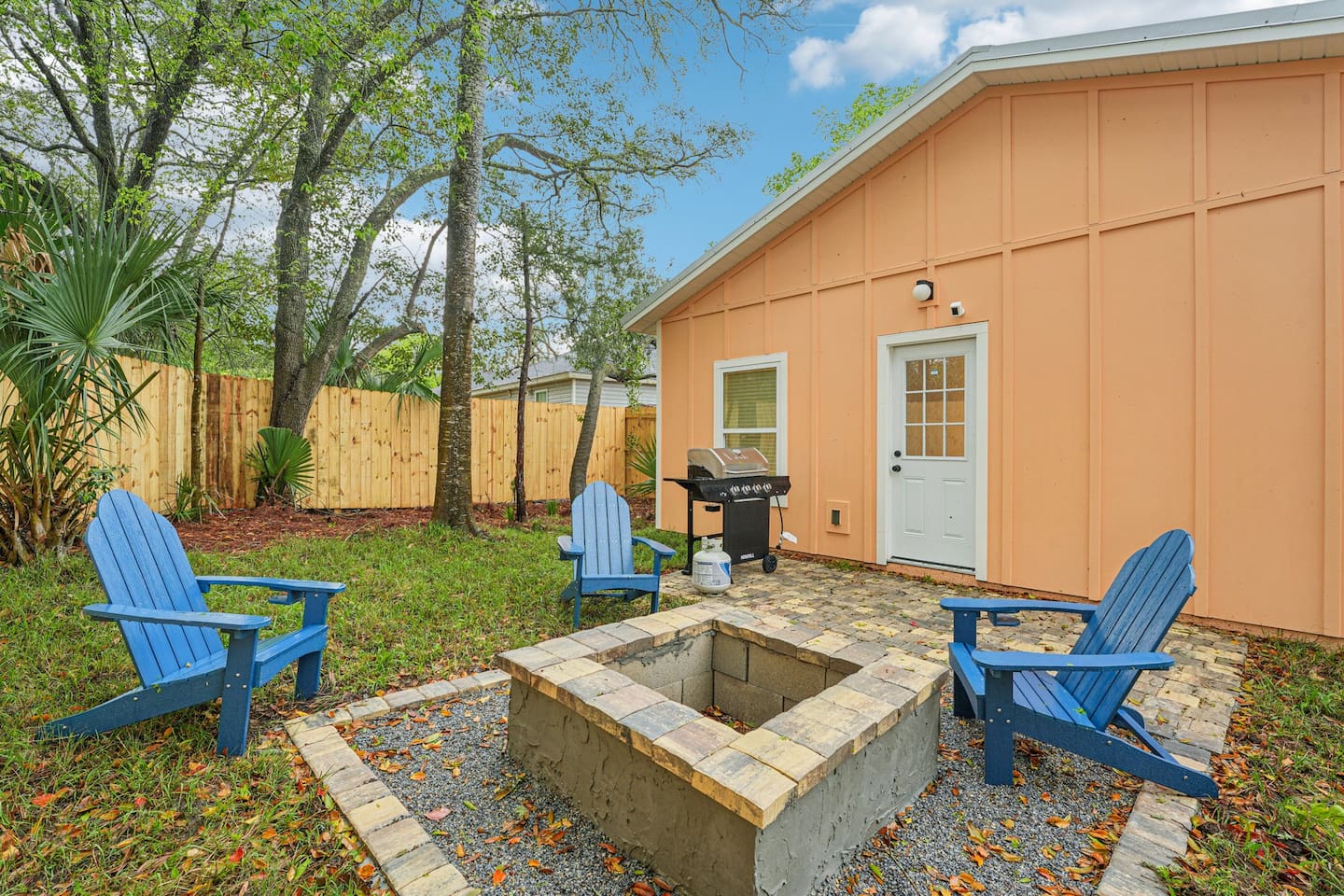 Outdoor area has a stone patio, stone fire pit, 4 adirondak-style chairs, and an 8-seat picnic table, with a fully fenced, private backyard.