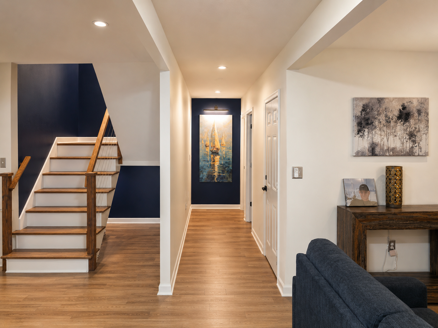 Main-floor living room with comfortable seating, warm lighting and easy access to the kitchen, dining area and upstairs loft.