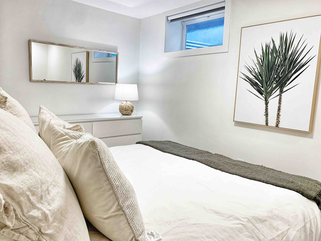 Primary bedroom with queen bed, blackout curtains, and a calm Scandinavian palette.