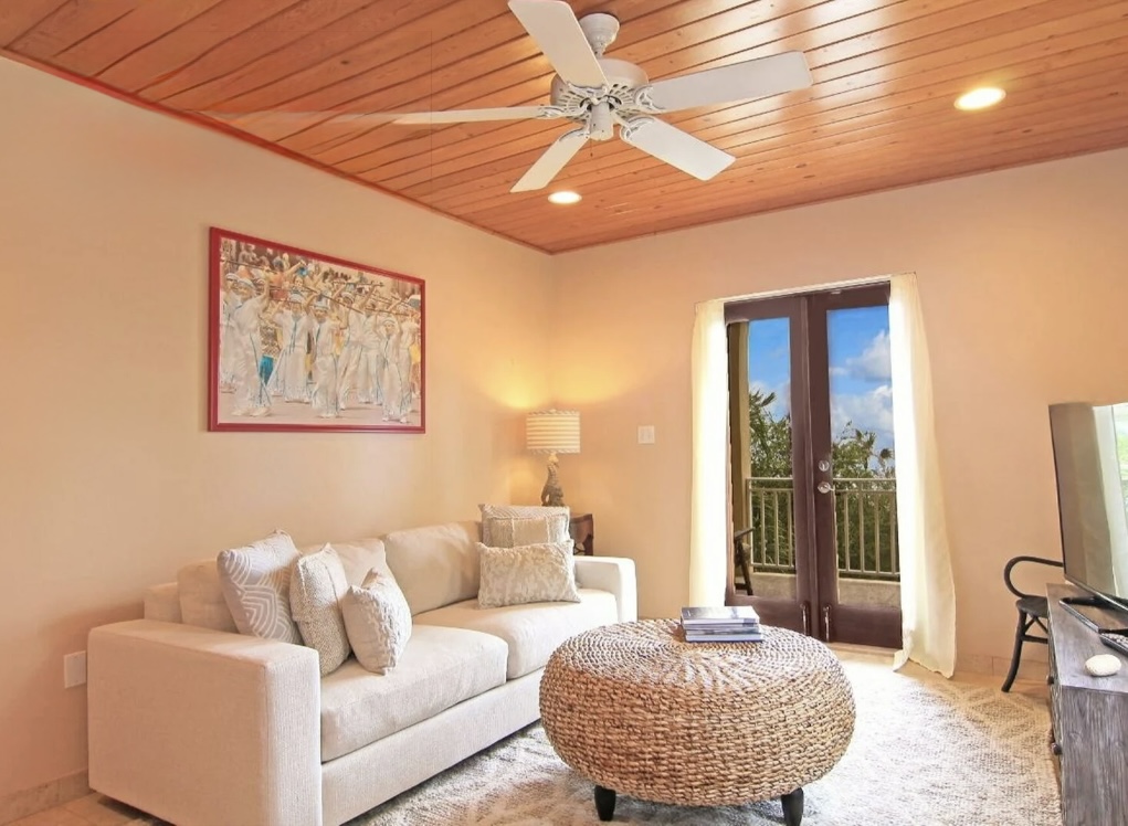 Comfortable lounge with smart TV and balcony access—quiet, cozy, and breezy after beach days.