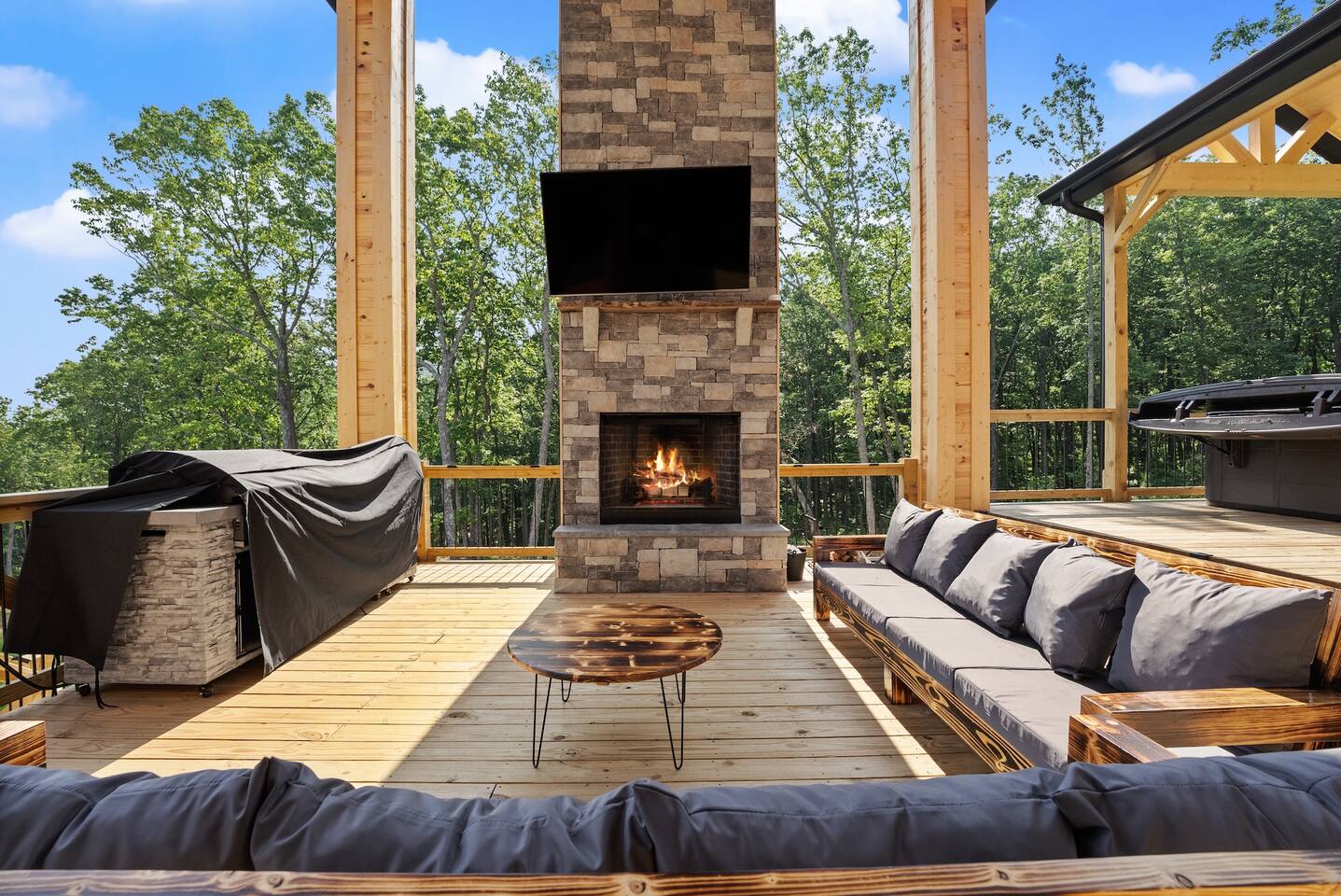 Cozy up by the crackling fireplace while enjoying the fresh mountain air and scenic forest views from the heart of the patio.