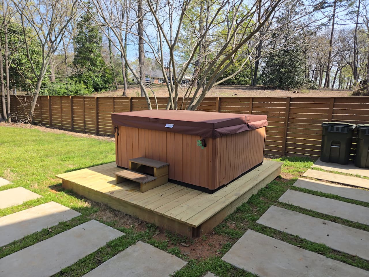 Enjoy a secluded backyard retreat featuring a premium hot tub, private deck, and peaceful surroundings—your perfect escape in Greenville.