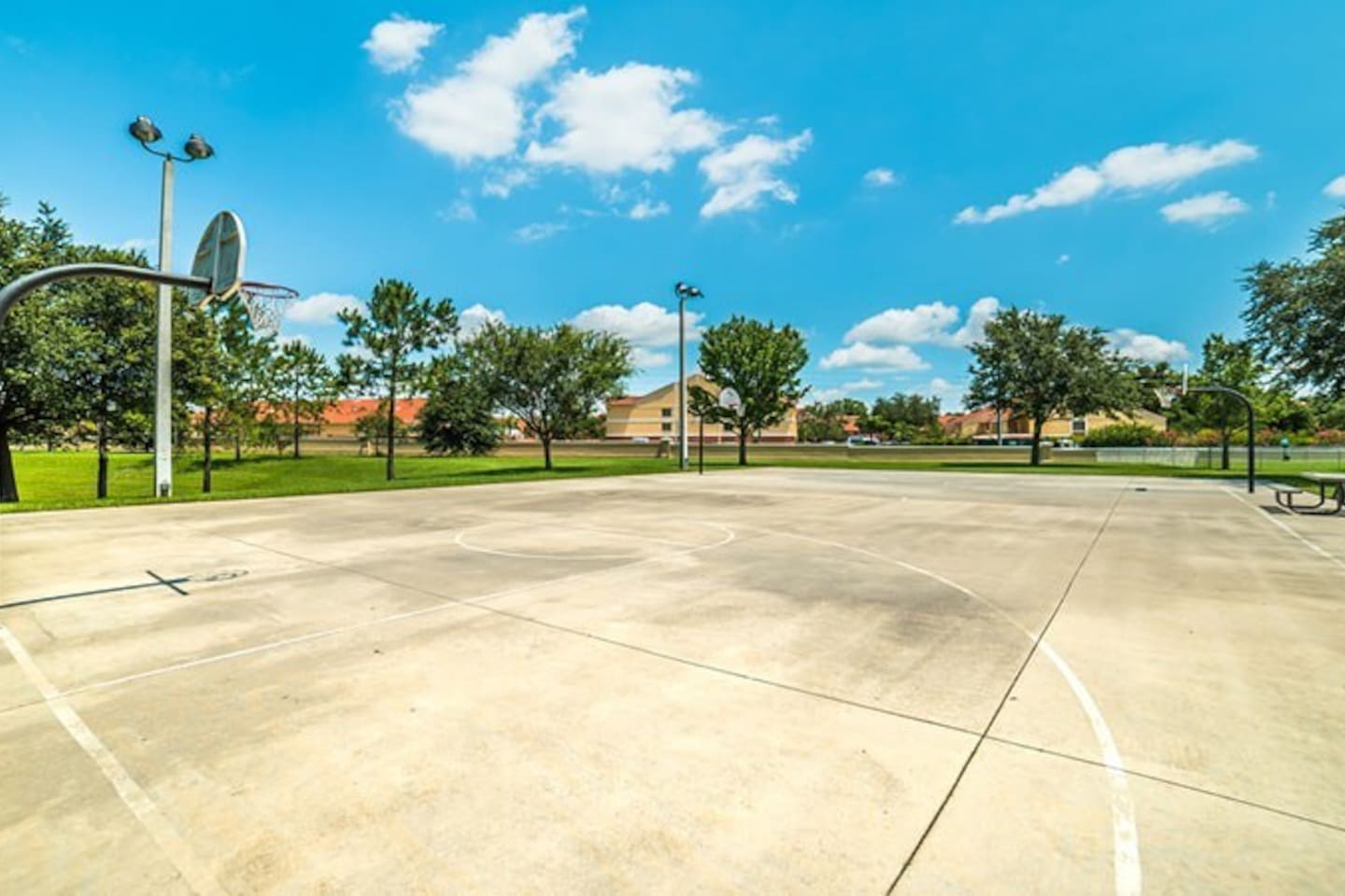 Full sized basketball court with open surroundings.

