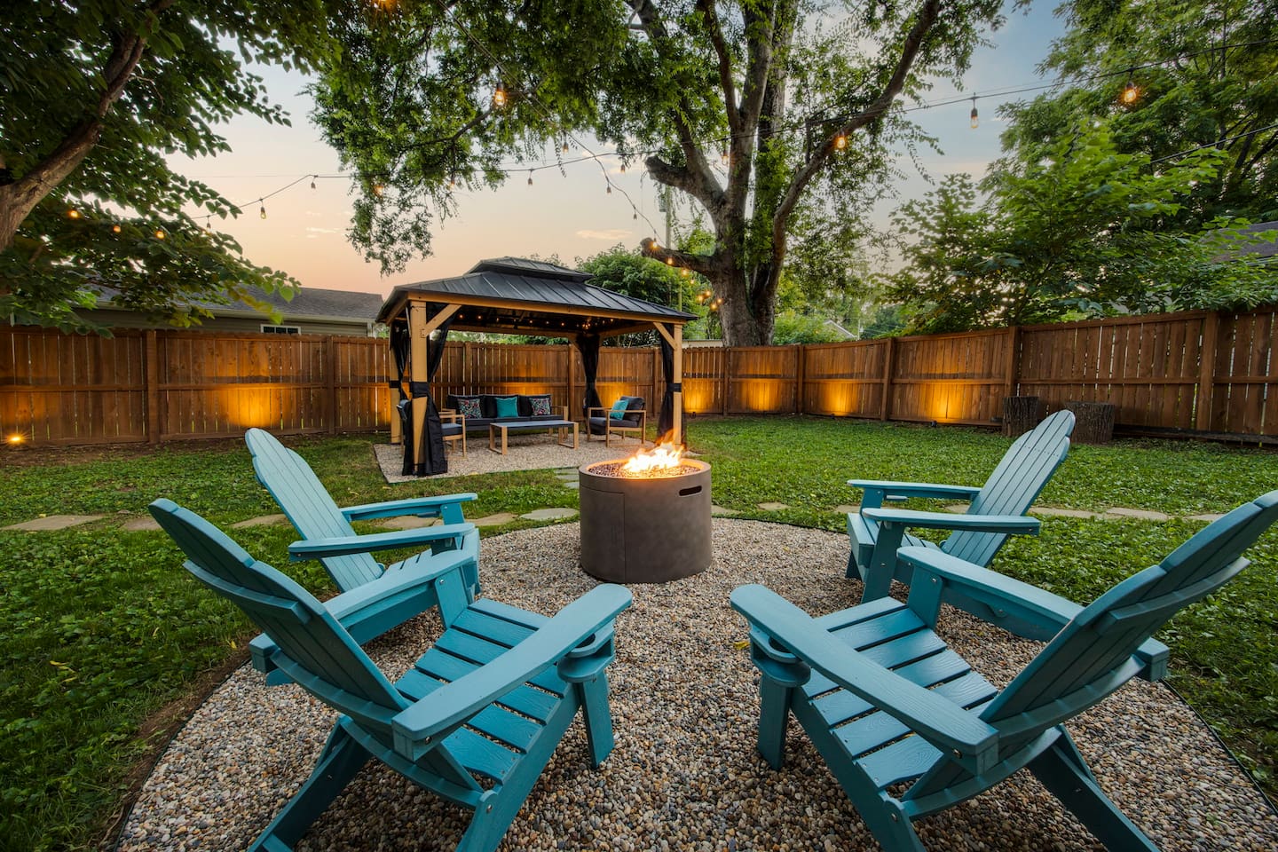 Backyard fire pit and seating area, surrounded by 6 foot privacy fence. Unwind, gather round, and enjoy your own oasis.