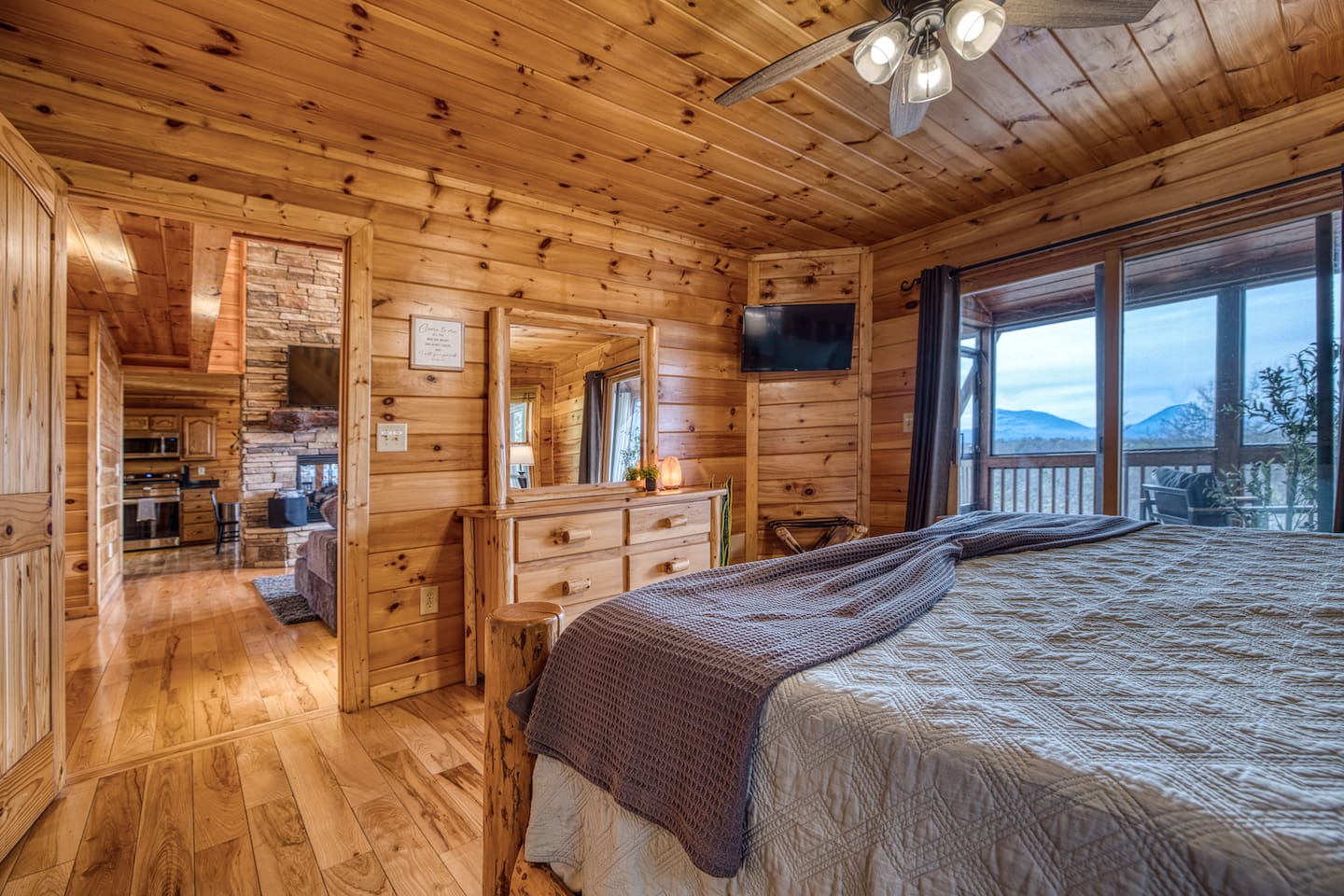 Main-level master bedroom includes a king bed, a private full bathroom, and mountain views! The screened-in patio is right off the master bedroom. 