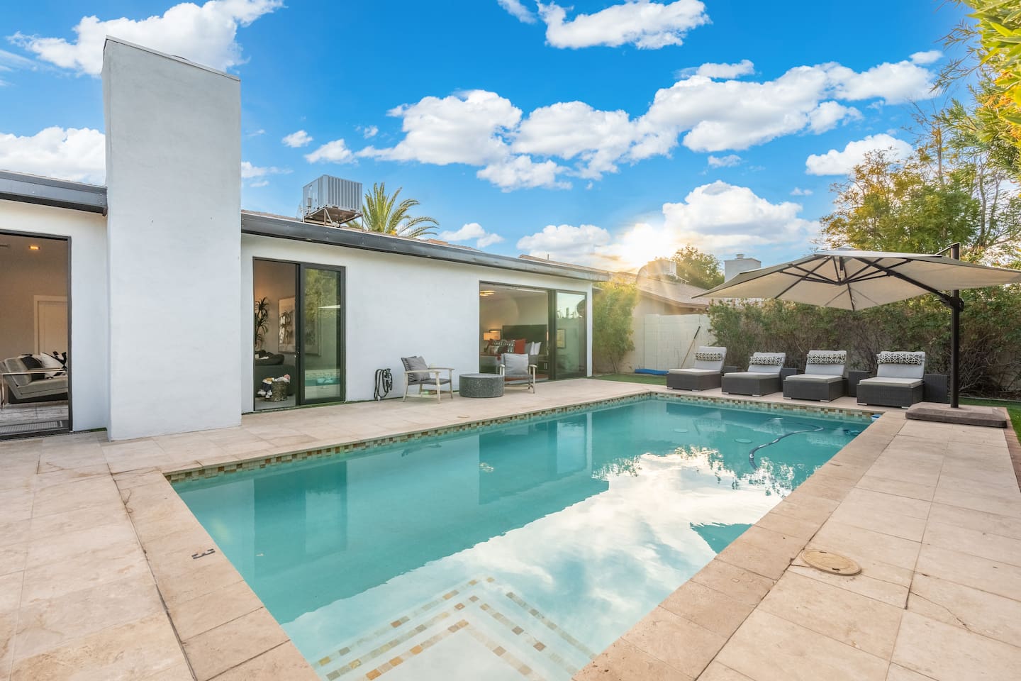 Bask in the beauty of a serene sunset beside the sparkling pool, complete with plush loungers and lush privacy hedges.