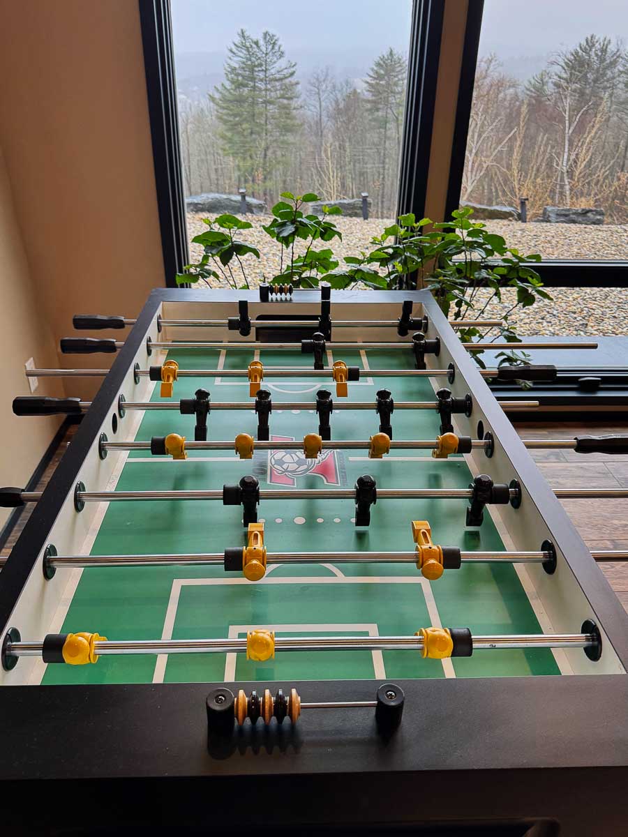 Foosball table in the Tavern Room with floor-to-ceiling glass to Berkshires mountain view &mdash; Sunset Falls