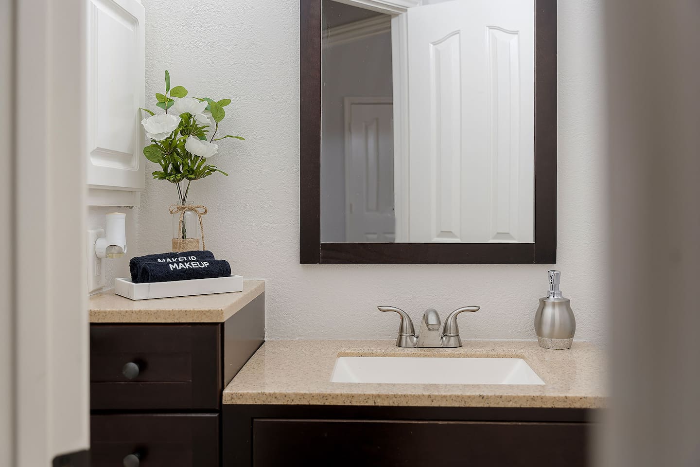 Step into this luxurious bathroom featuring a sleek sink and mirror combo and a spacious walk-in shower. Pamper yourself in style and comfort.