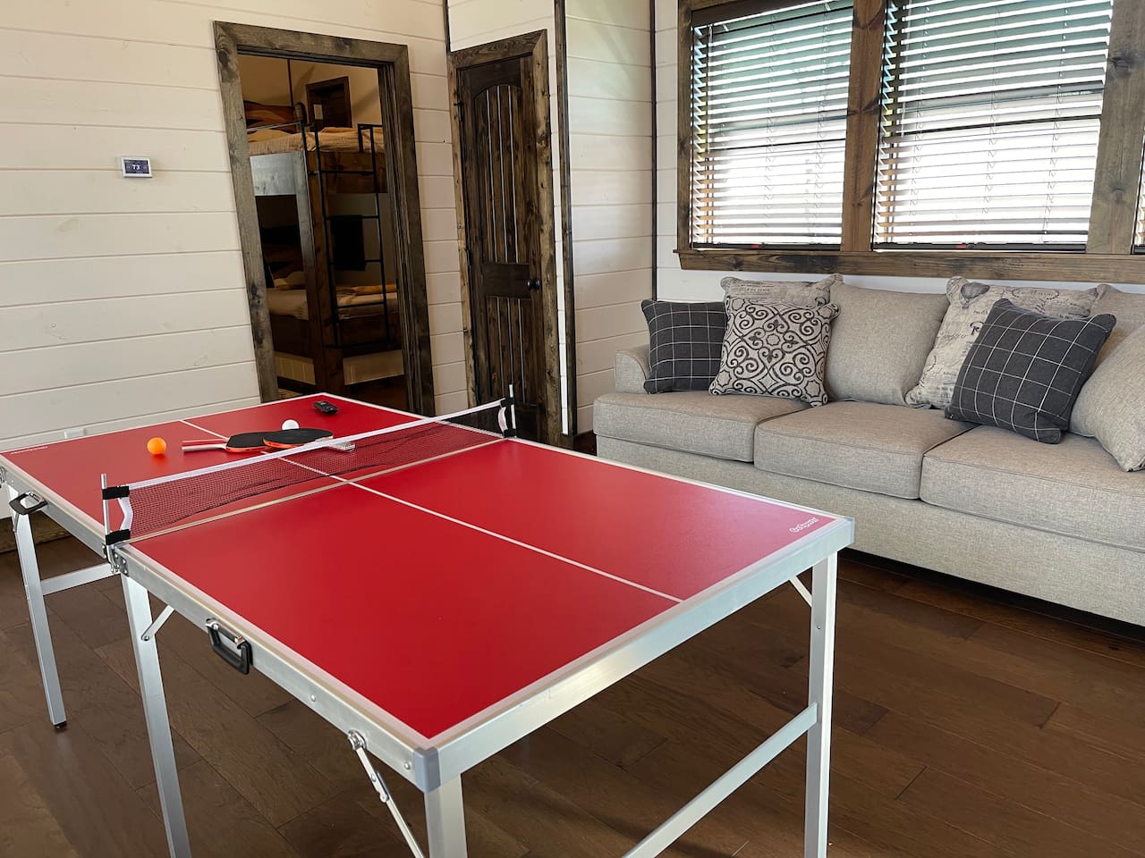 Ping pong table and new sleeper sofa, in the background is the bunk room.