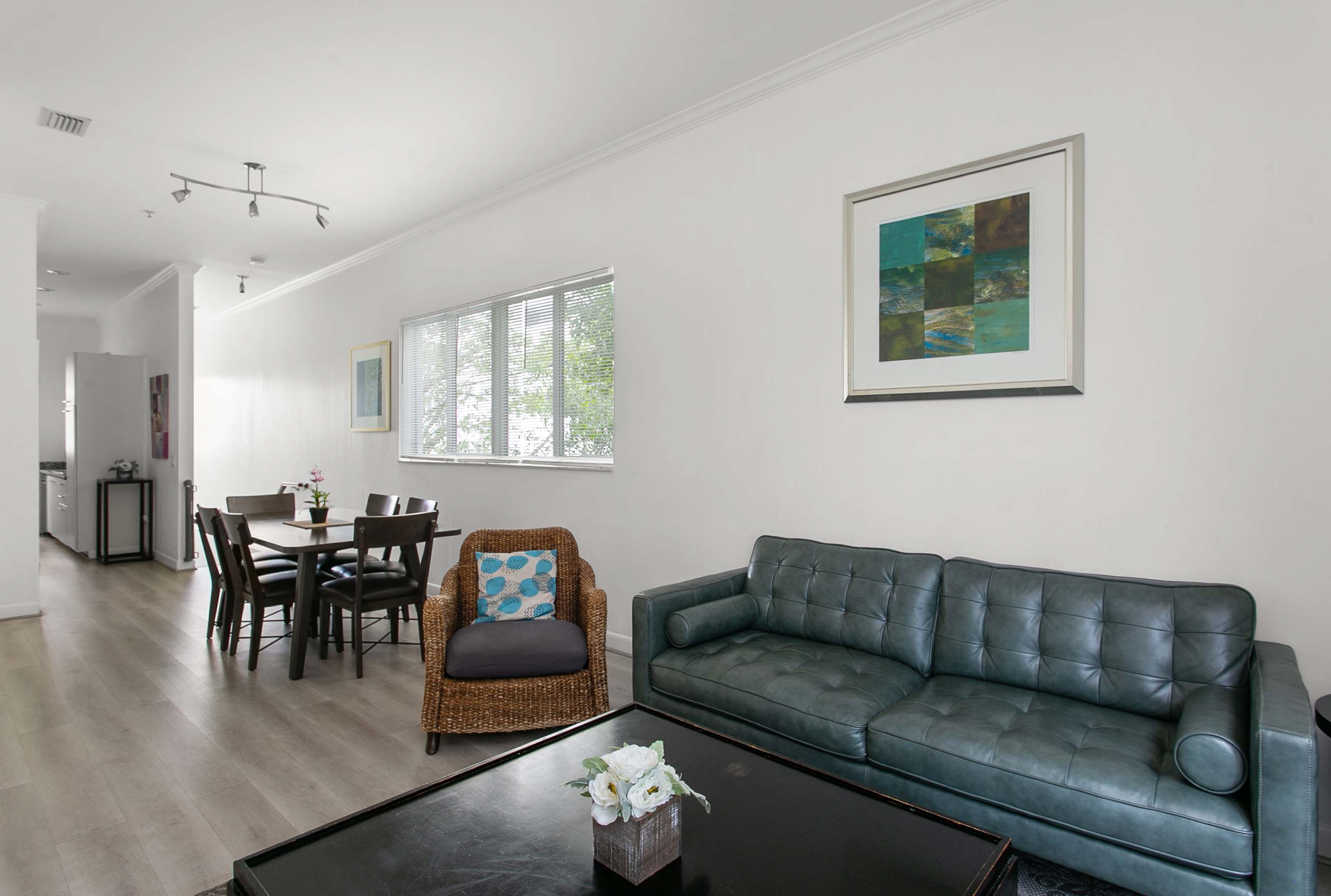 Open-concept living and dining, sliding glass doors open to a step-out balcony.