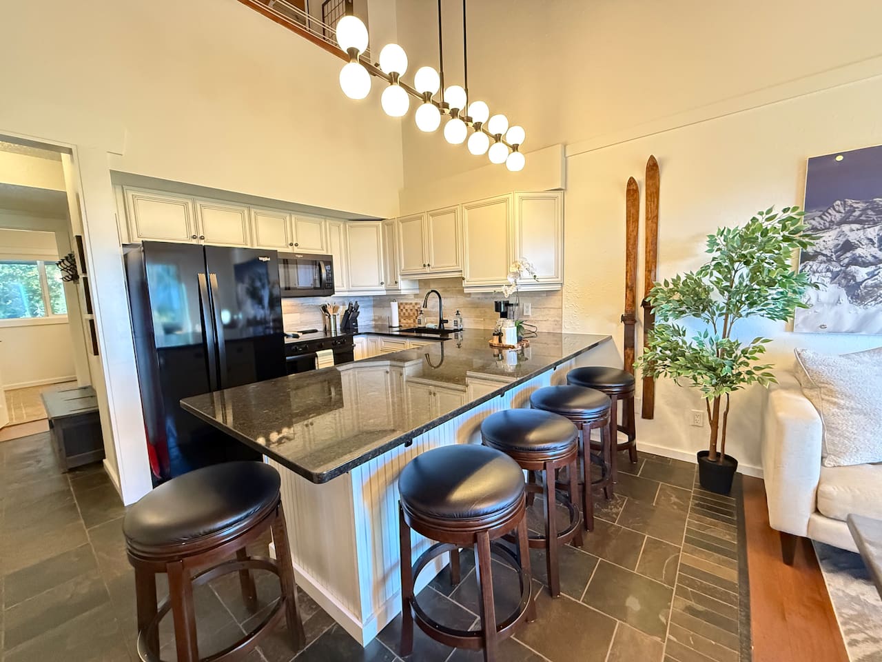 Kitchen & Dining Overview: The sleek kitchen features a large island that seats 5 and quality Whirlpool appliances, including a modern glass top stove and side-by-side fridge, at your Kimberley rental.