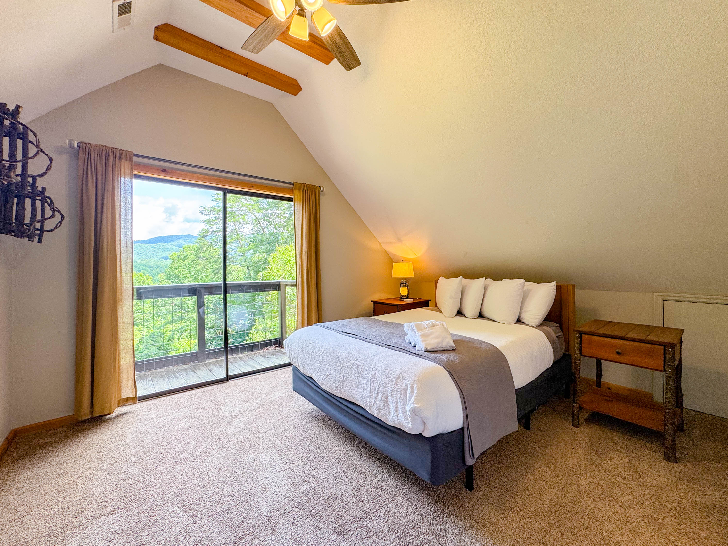The front upper eave bedroom features a queen memory foam hybrid bed with shredded bamboo pillows. Did I mention the views! There is a private Juliet balcony off this room.