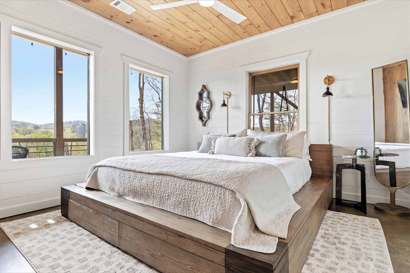 This bright and airy bedroom features a cloud like Serta mattress bed with storage drawers. Large windows fill the space with natural light and peaceful mountain views, while the warm wood ceilings and neutral tones create a calm, inviting retreat.