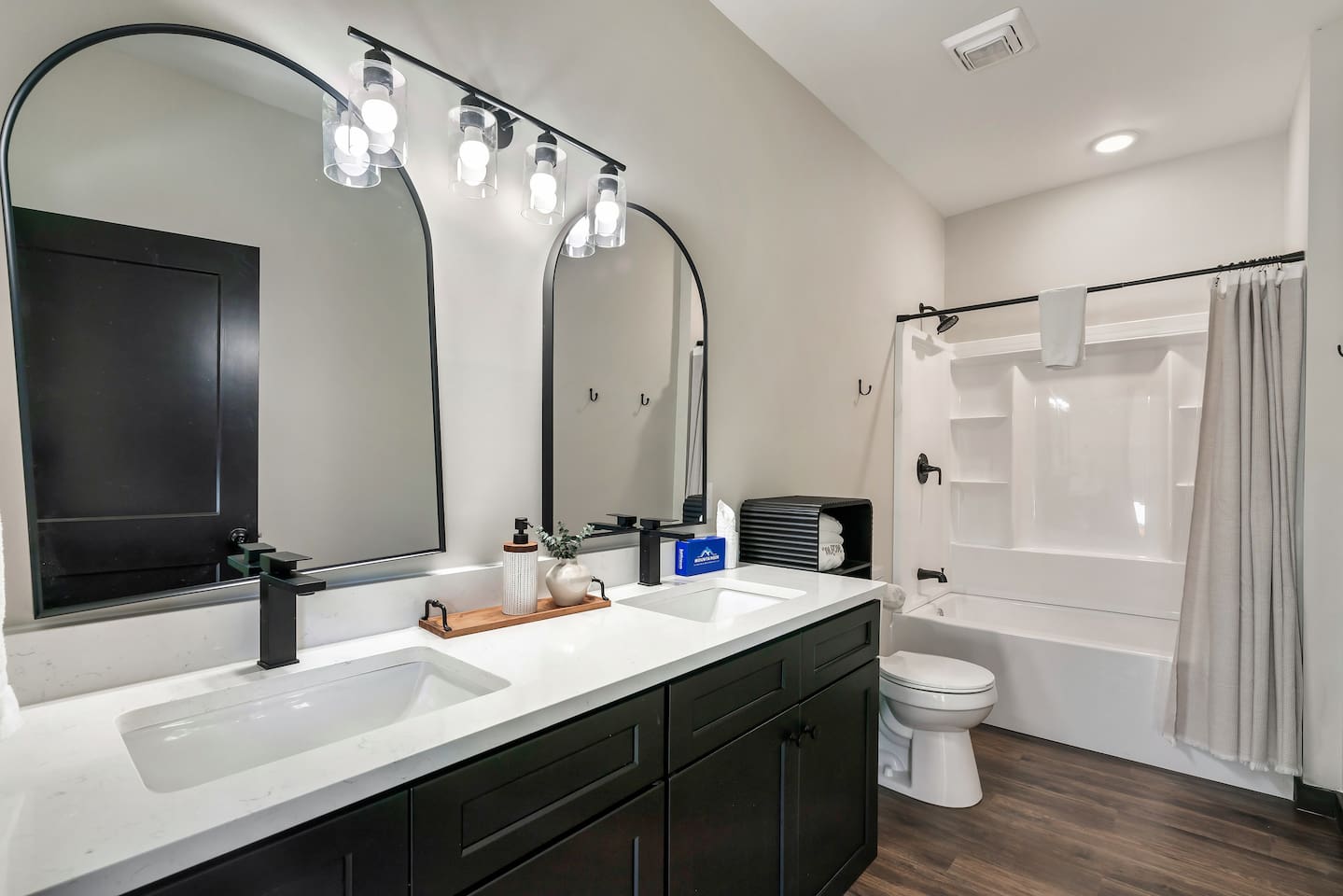 Lower-level full bathroom with double vanity and shower/tub combo.