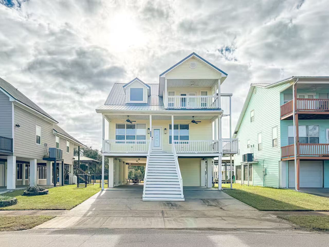 Beautiful elevated coastal home with spacious balconies, private parking, and a bright, welcoming exterior