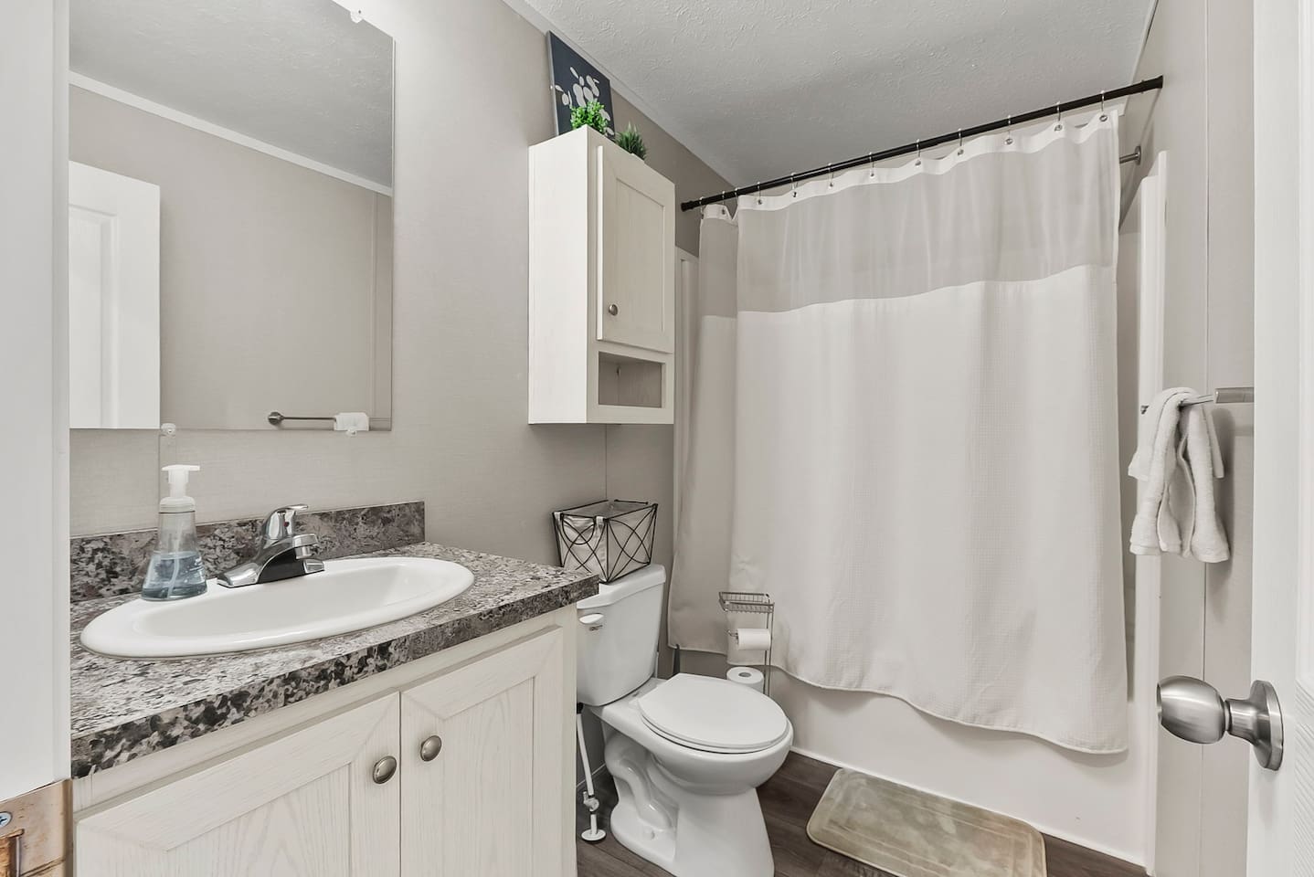 Clean and functional full bathroom with shower-tub combo, bright lighting, and plenty of space to refresh.