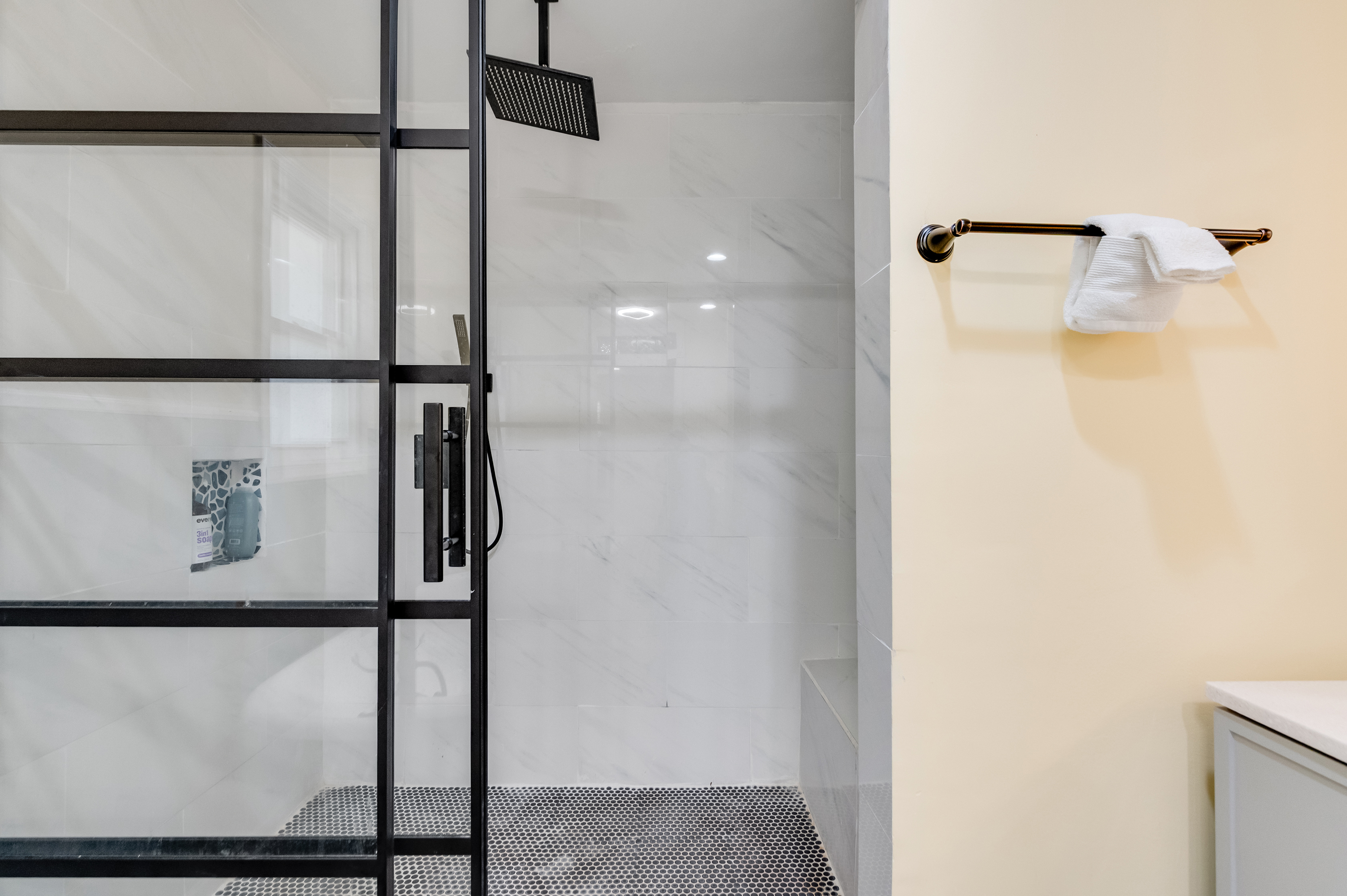 Upstairs Ensuite Full Bathroom 2: Refresh in a stunning walk-in shower with stylish glass and marble accents!