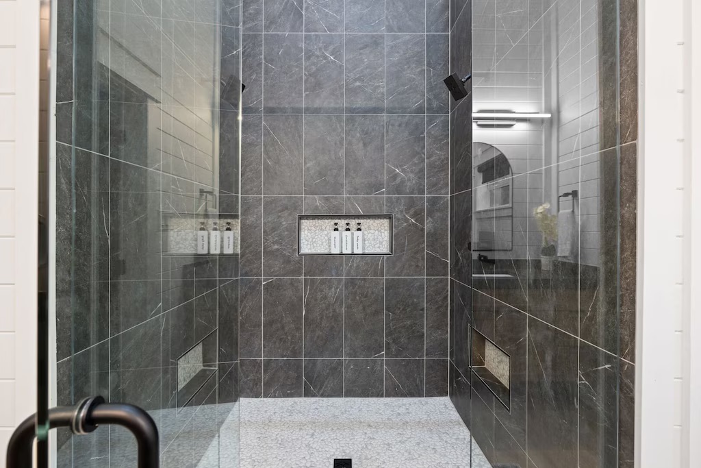Luxurious Shower Retreat: Indulge in elegant stone finishes and refreshing rain shower touches!