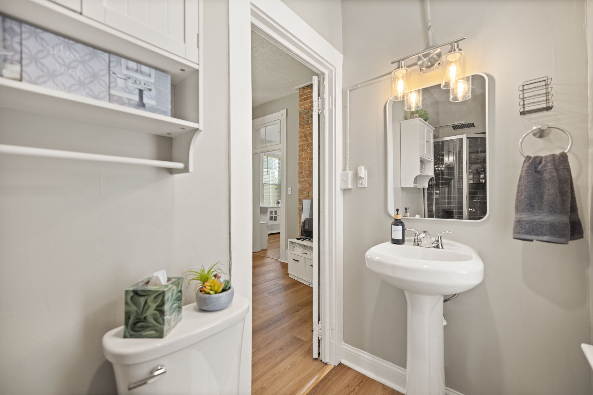 full bathroom with pedestal sink, clean white fixtures, and bright natural light