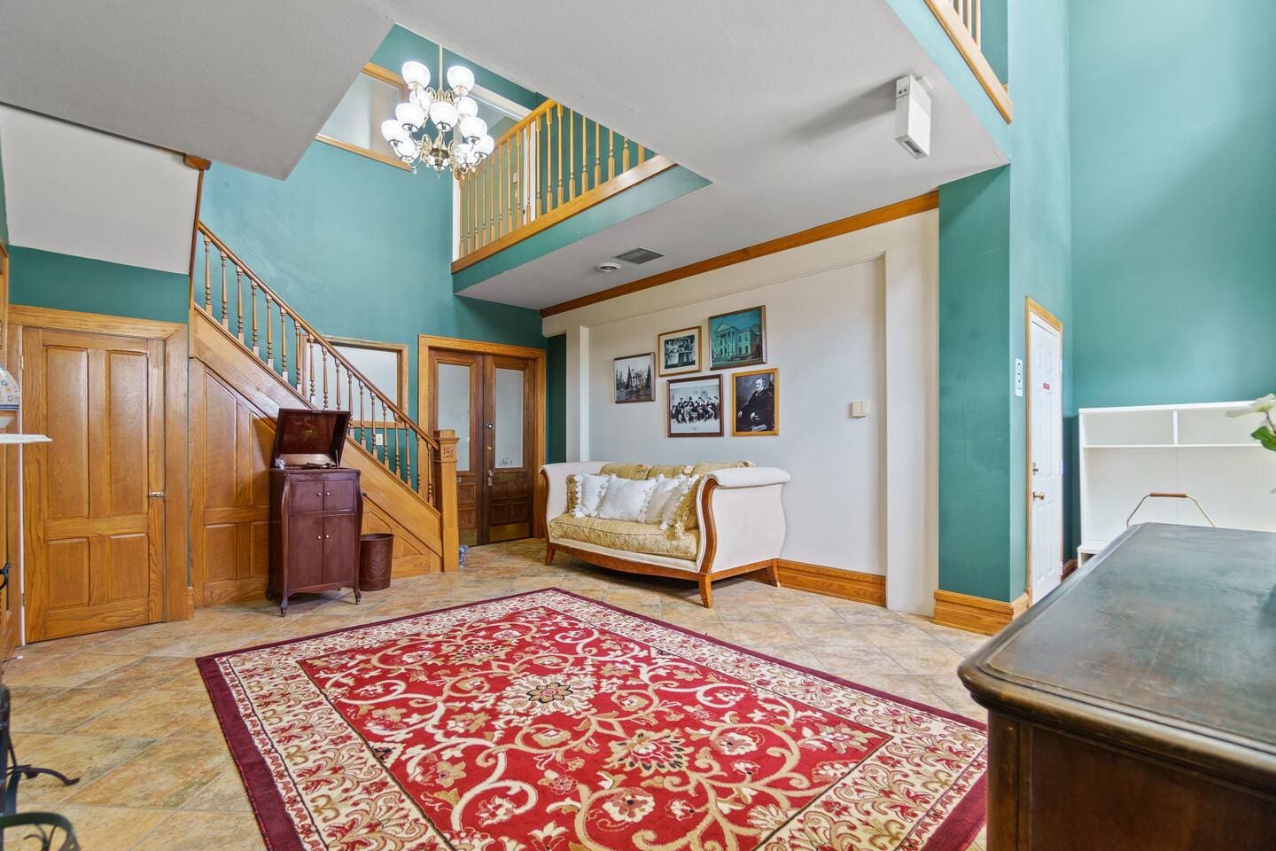 Spacious living area featuring a large red carpet and stairs leading to the second floor, offering a cozy and inviting atmosphere.