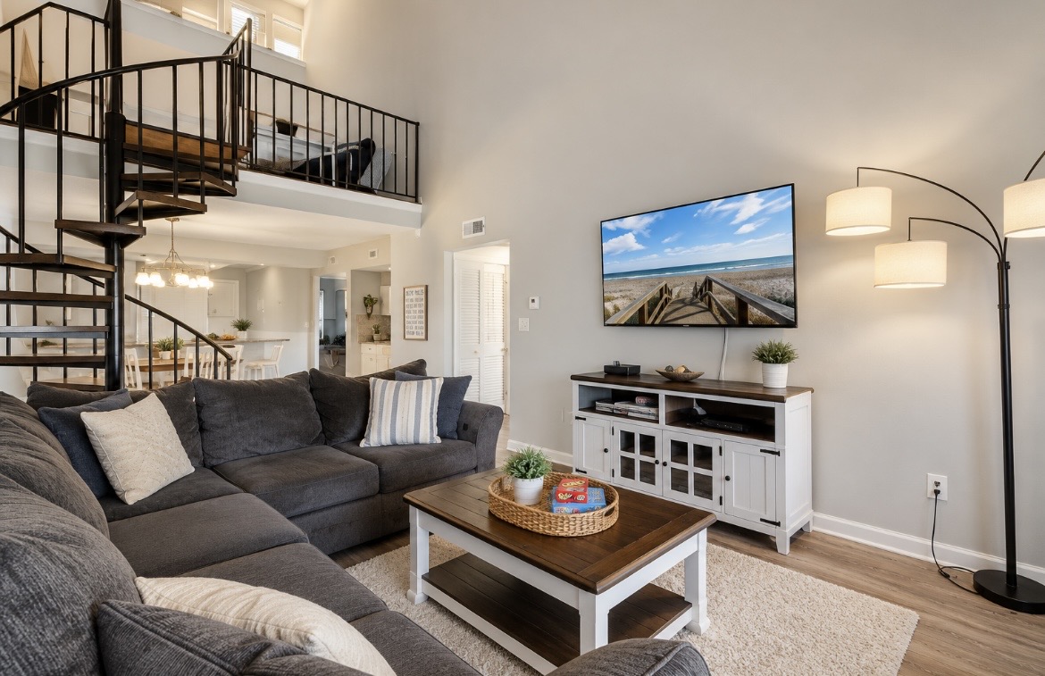 Relax in the comfortable living area with plenty of seating and a TV for movie nights. The spiral staircase adds character to this inviting space. ⭐