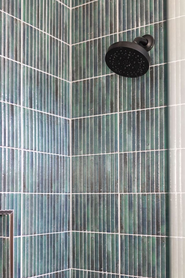 Close-up of the rainfall showerhead and elegant tile detail for a spa-like experience.