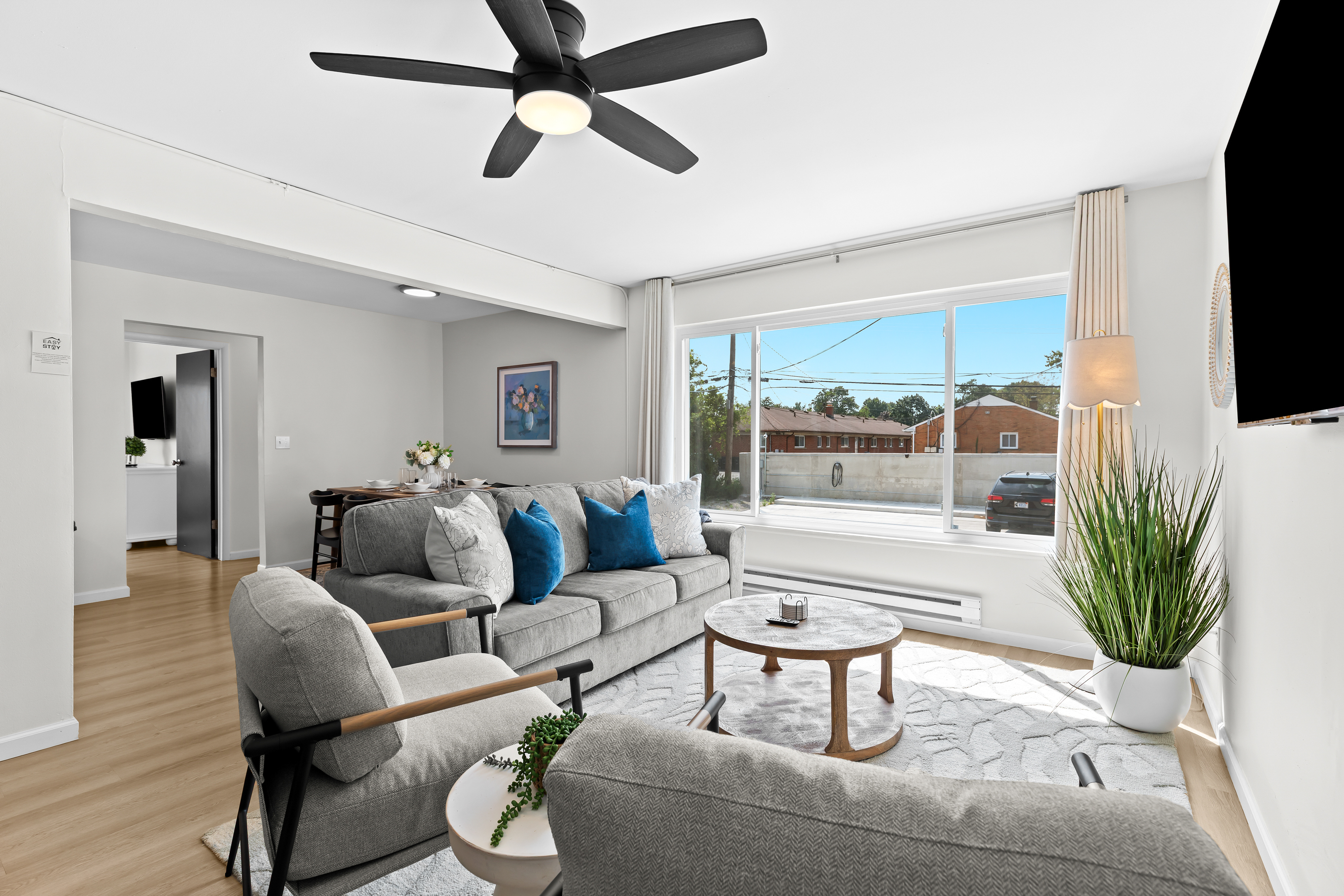 Relax in this sun-filled living space with cozy seating, stylish décor, and a large picture window offering plenty of natural light.