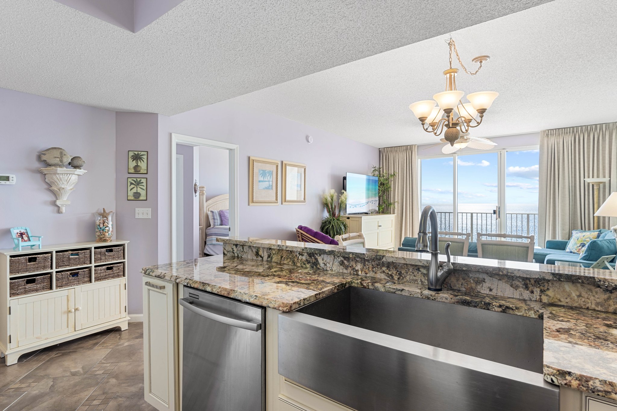 Wide-angle look at the main living space connecting kitchen & seating areas.