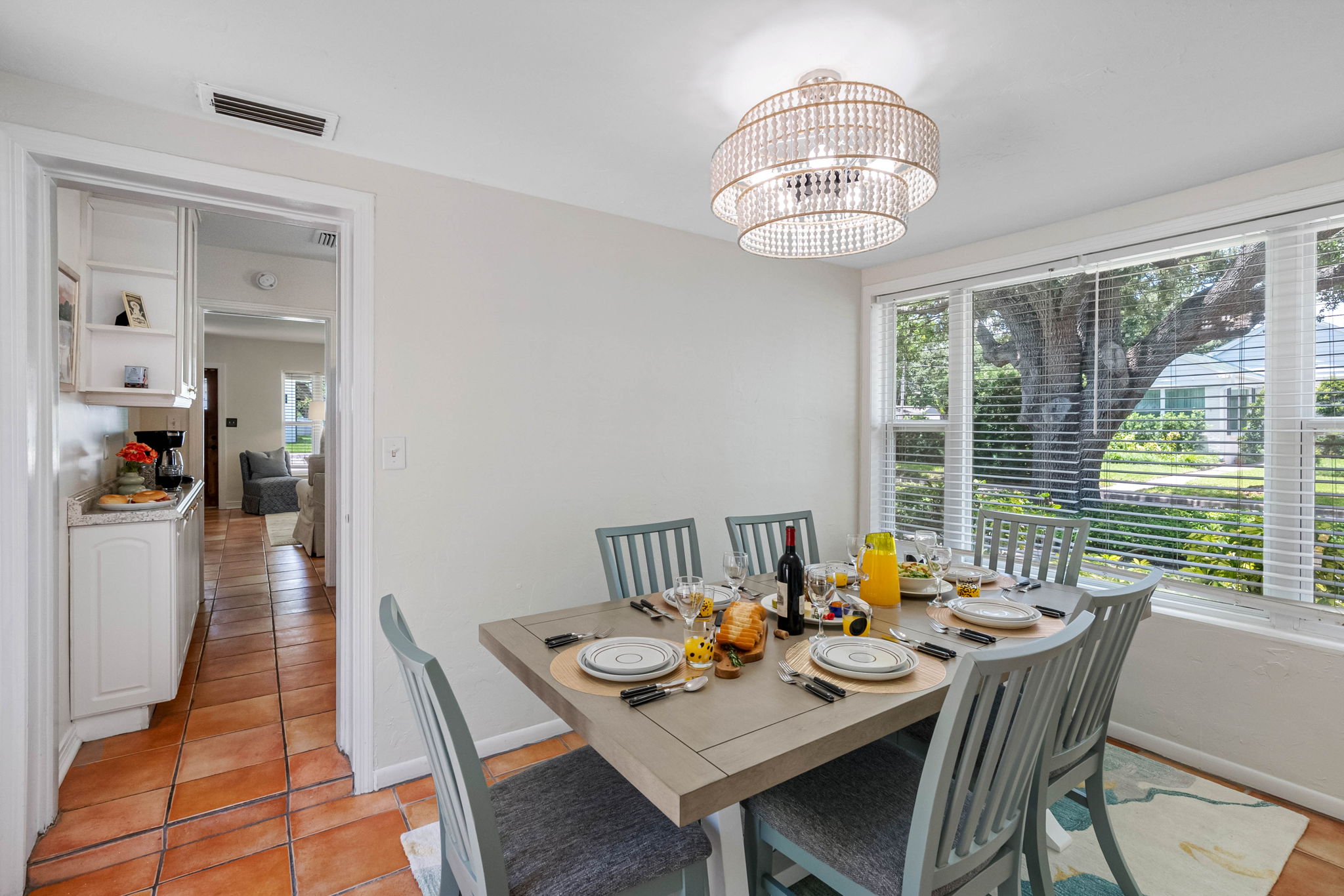 The view of the lush back yard and leafy oak tree brings the outdoors in—offering a serene, Florida-style dining experience.