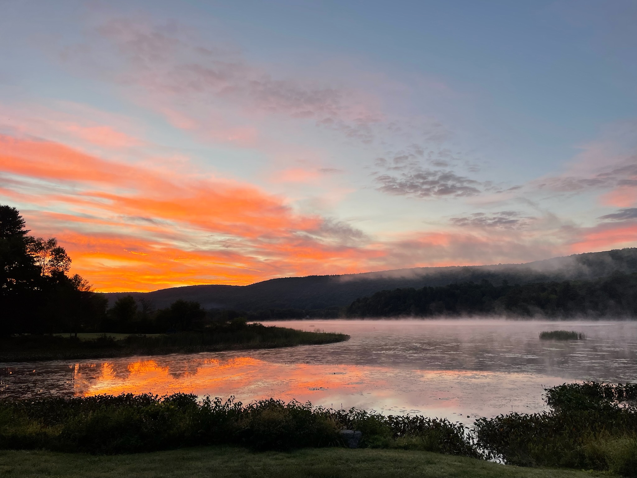 Rising morning fog under nature's painted sky