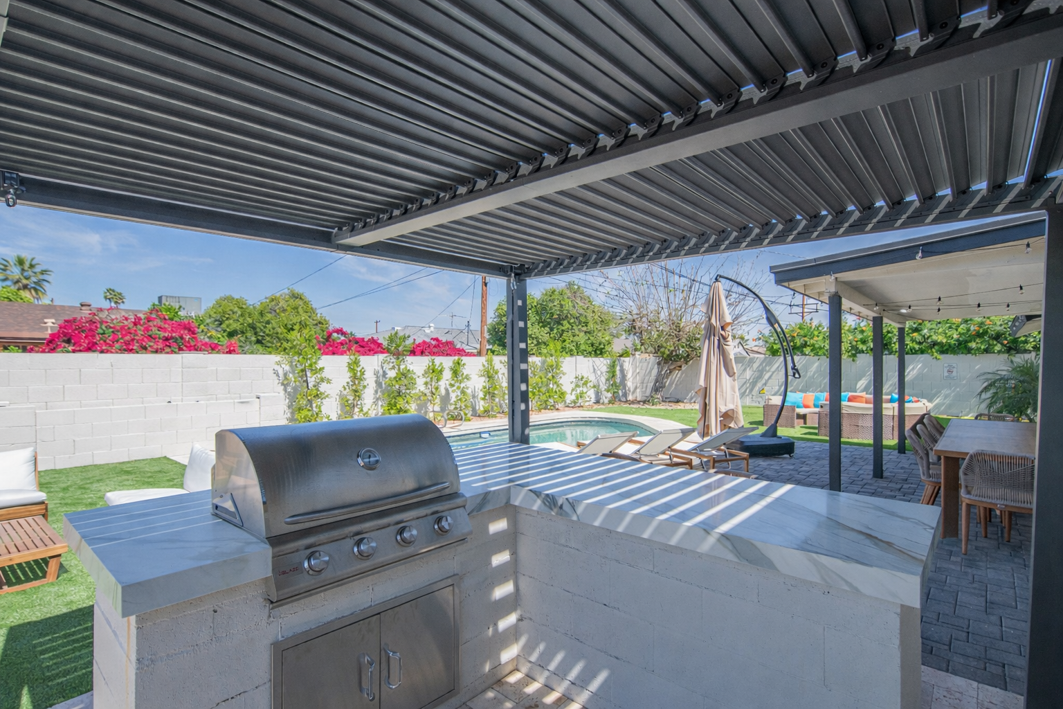Covered outdoor kitchen with built-in BBQ and shaded prep space
