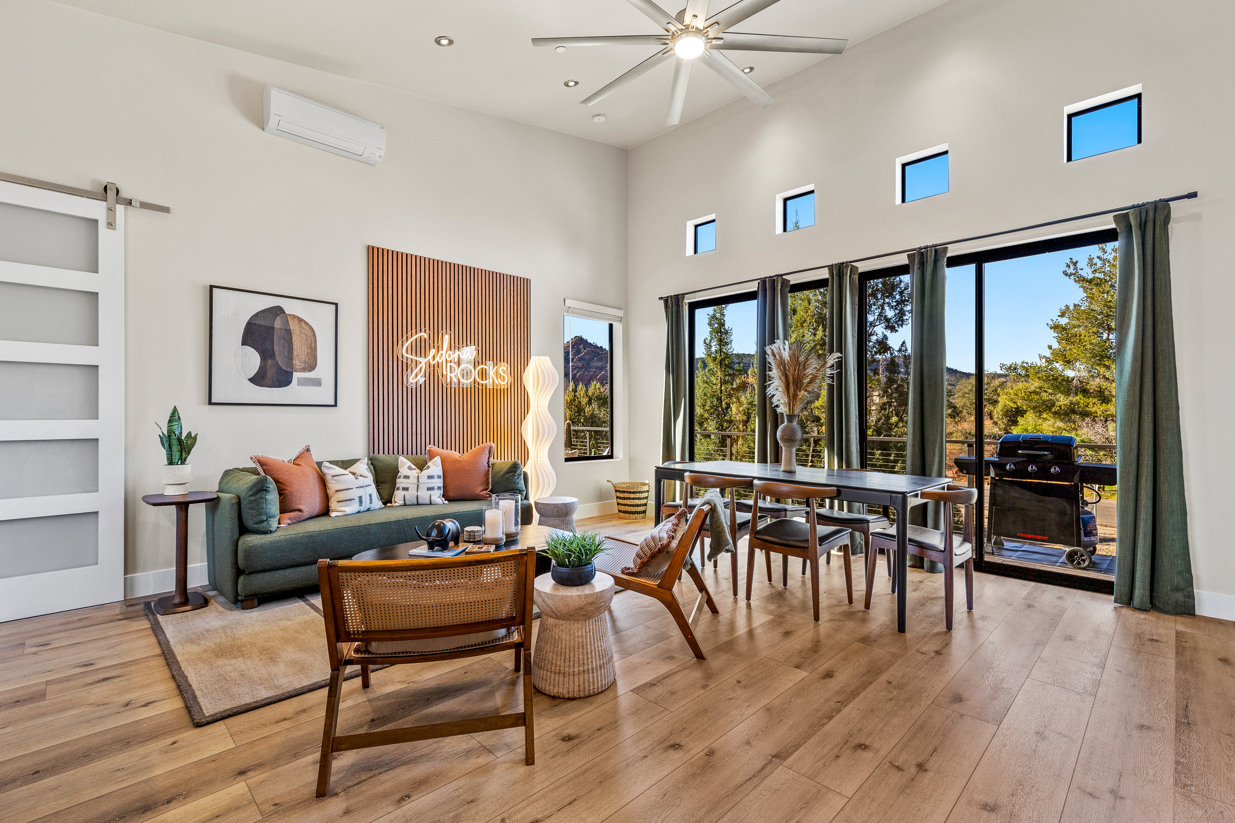 A spacious living and dining area with large windows, comfortable seating, and easy access to the deck - designed for relaxing, gathering, and enjoying Sedona’s natural light. 