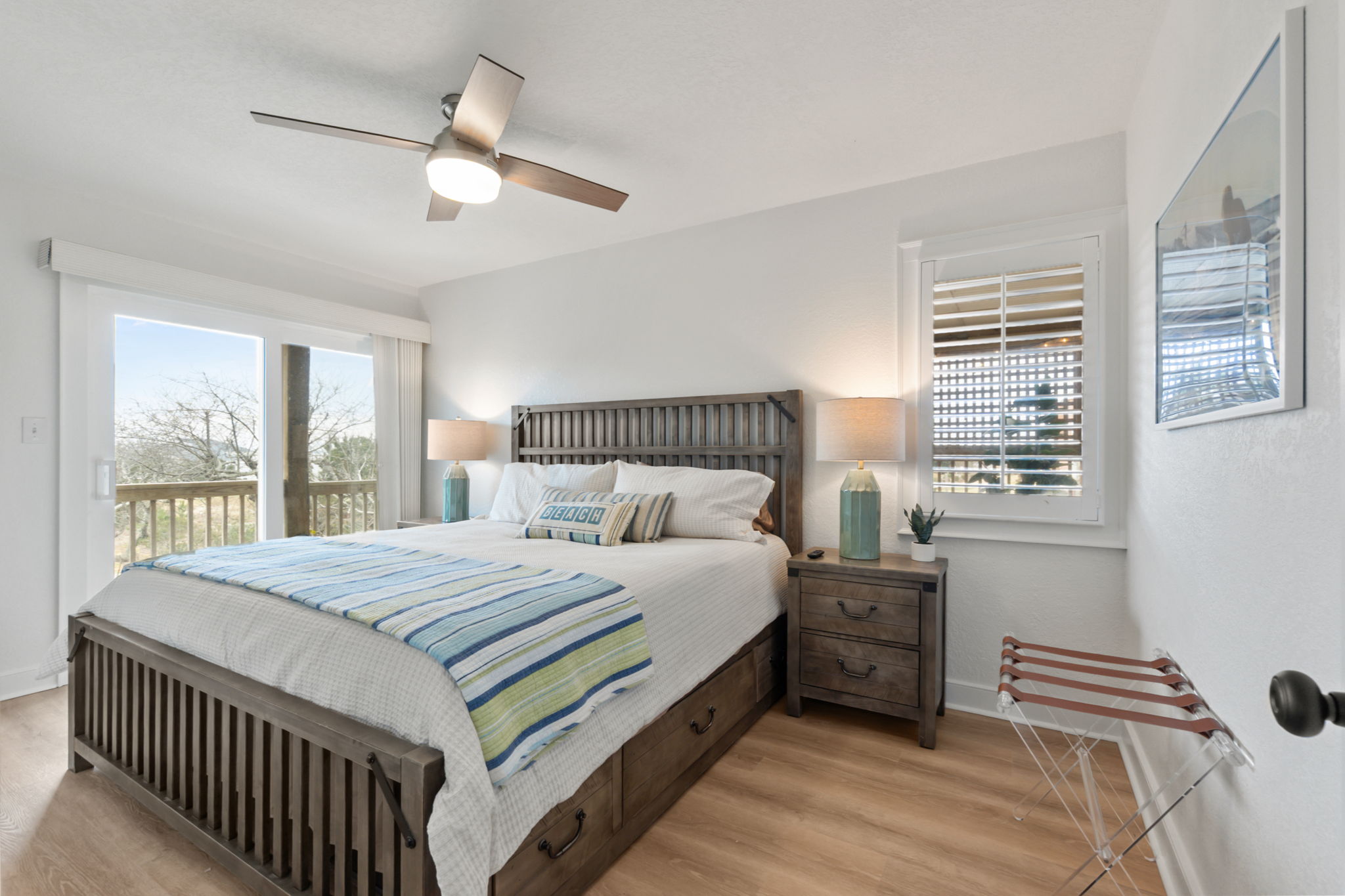 Queen Bedroom #1 – Bright bedroom with a queen bed and deck access, filled with natural light.