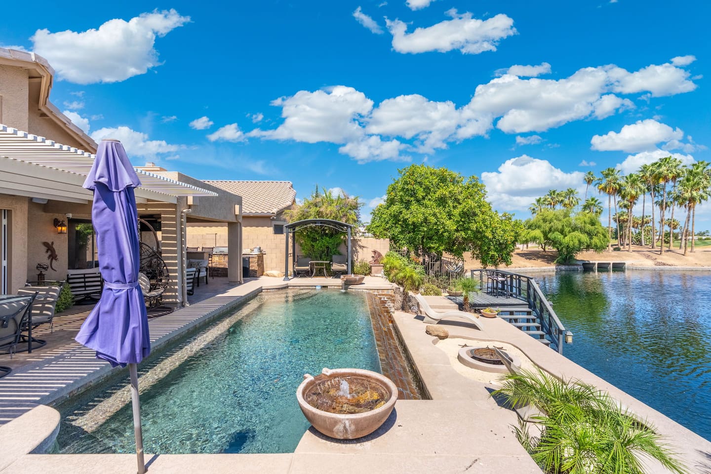 From the pool deck to the lake stairs, this backyard invites you to wander — cool off in the water, sit by the fountain bowl, or walk down to the lake's edge.