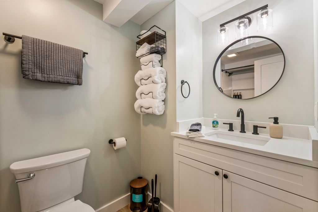 Full bathroom along the hallway with large shower, vanity, and storage.