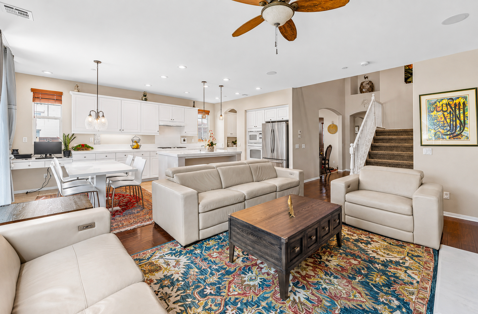 Open living room with comfy seating, a full kitchen nearby, and space for everyone to hang out.
