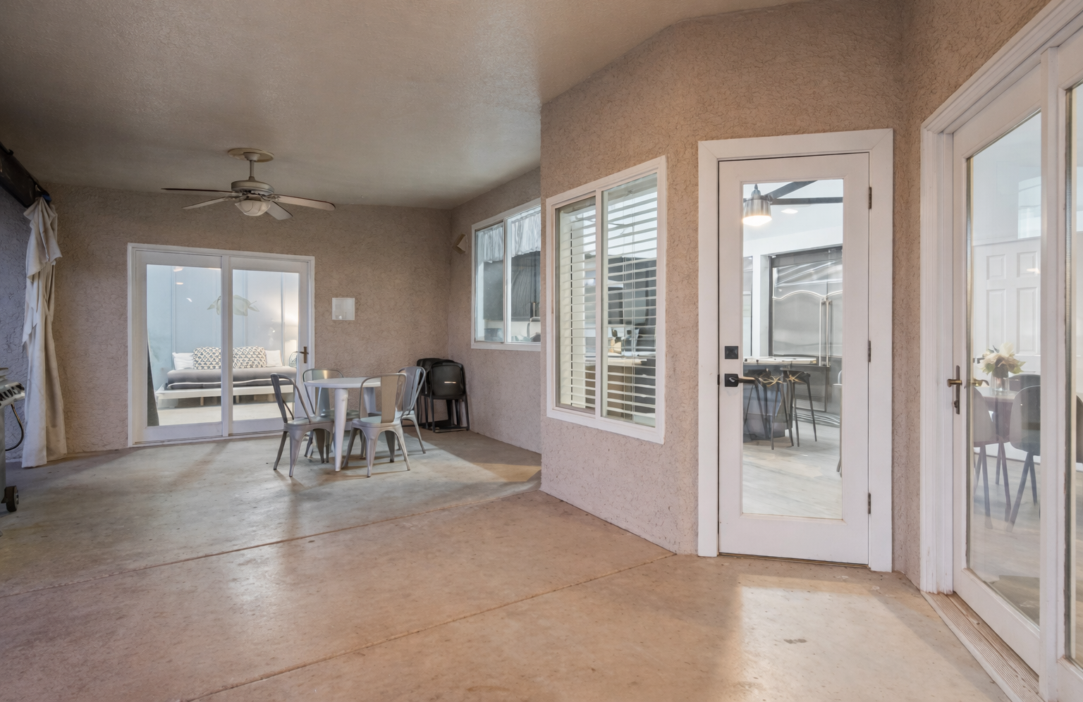 Dine outdoors under the covered patio with ceiling fans and fresh air just steps from the kitchen and pool.