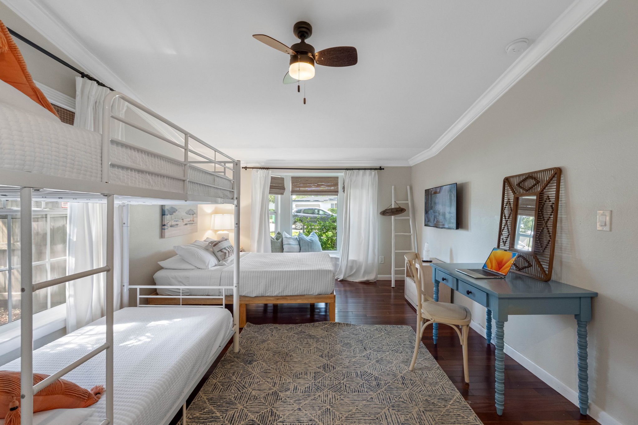 Stylish yet functional bedroom with white walls, crown molding, and warm hardwood floors.