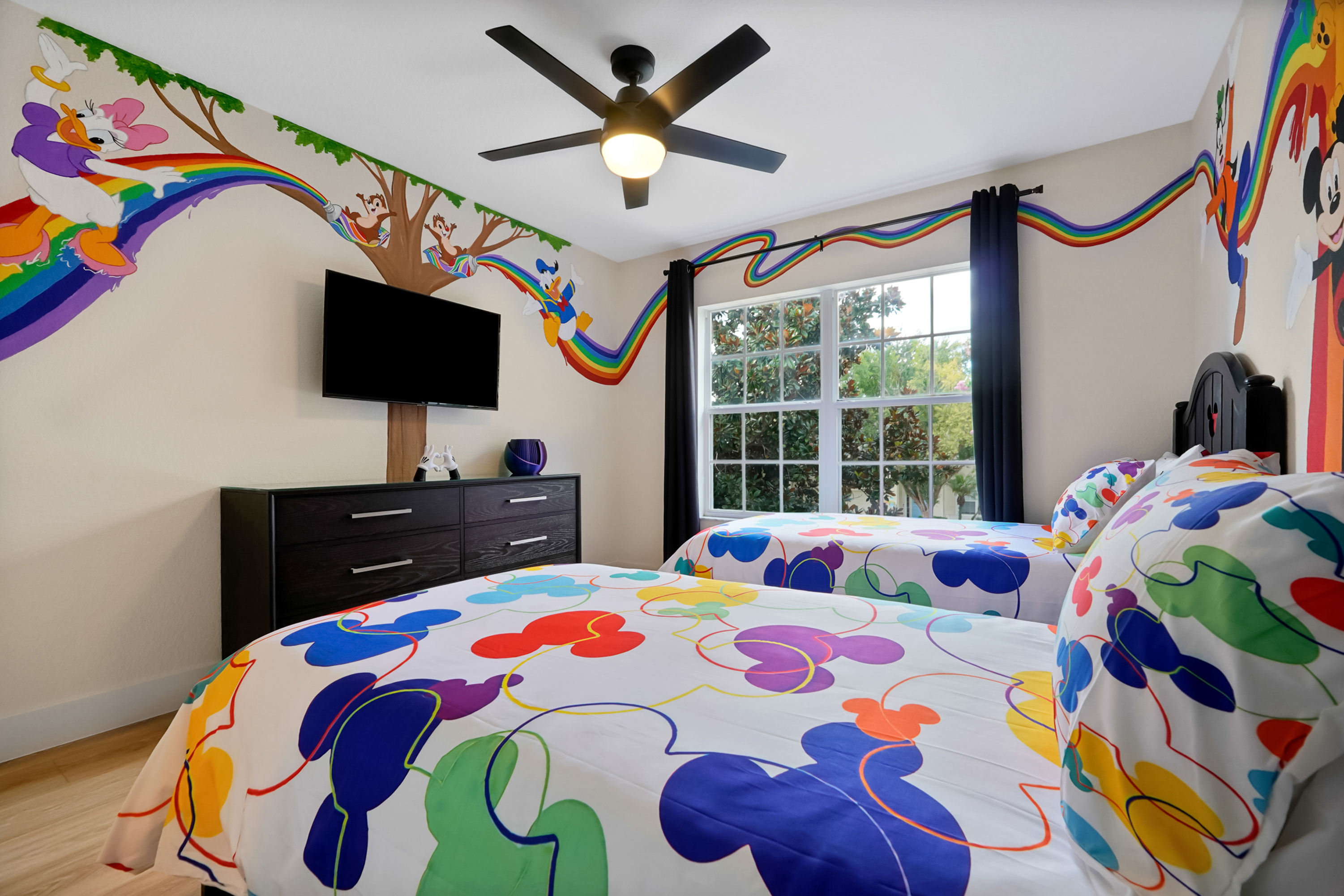 Mickey’s Rainbow Magic: Bright twin bedroom with TV and immersive hand-painted mural featuring favorite Disney characters.