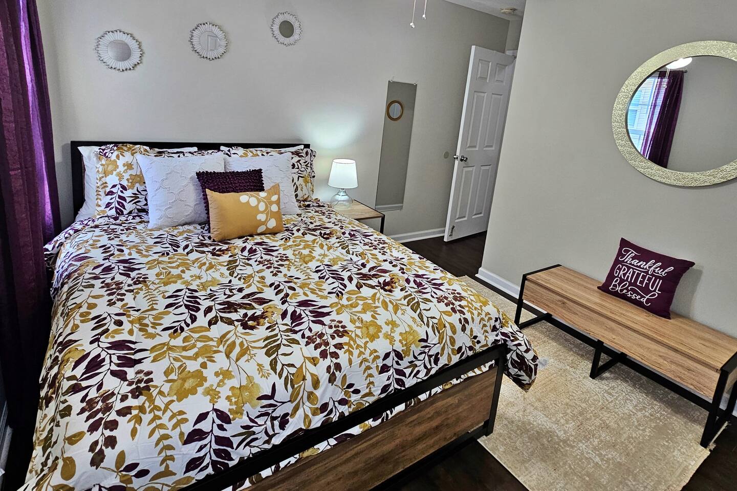 Enjoy this simple but unique guest bedroom. There is a bench that also serves as storage. The room also has a full-length mirror. 