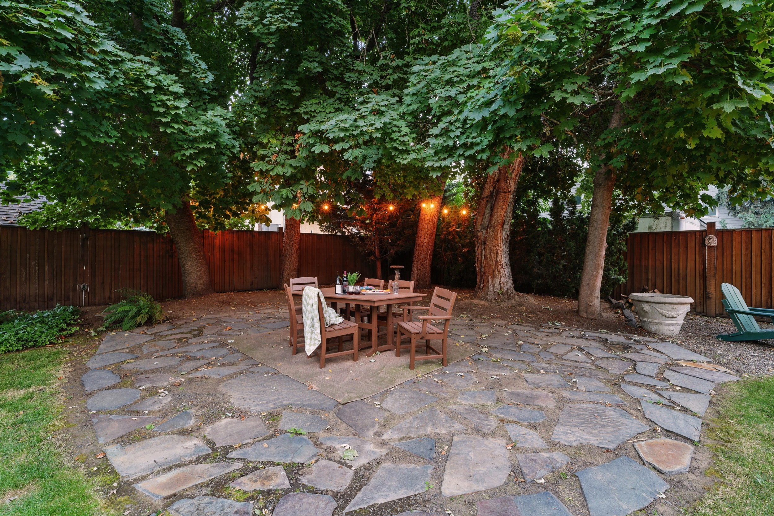 Large backyard with a park-like setting, outdoor dining for 6, corn hole, and 6 lounge chairs gathered around the fire table (propane provided)