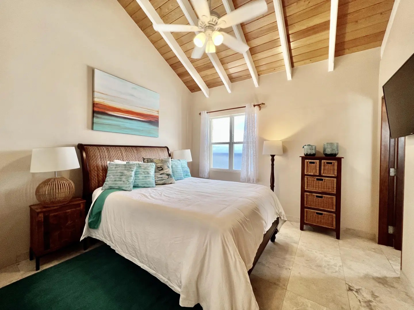 Guest bedroom with vaulted ceilings and ocean view—wake up to blue water every day.